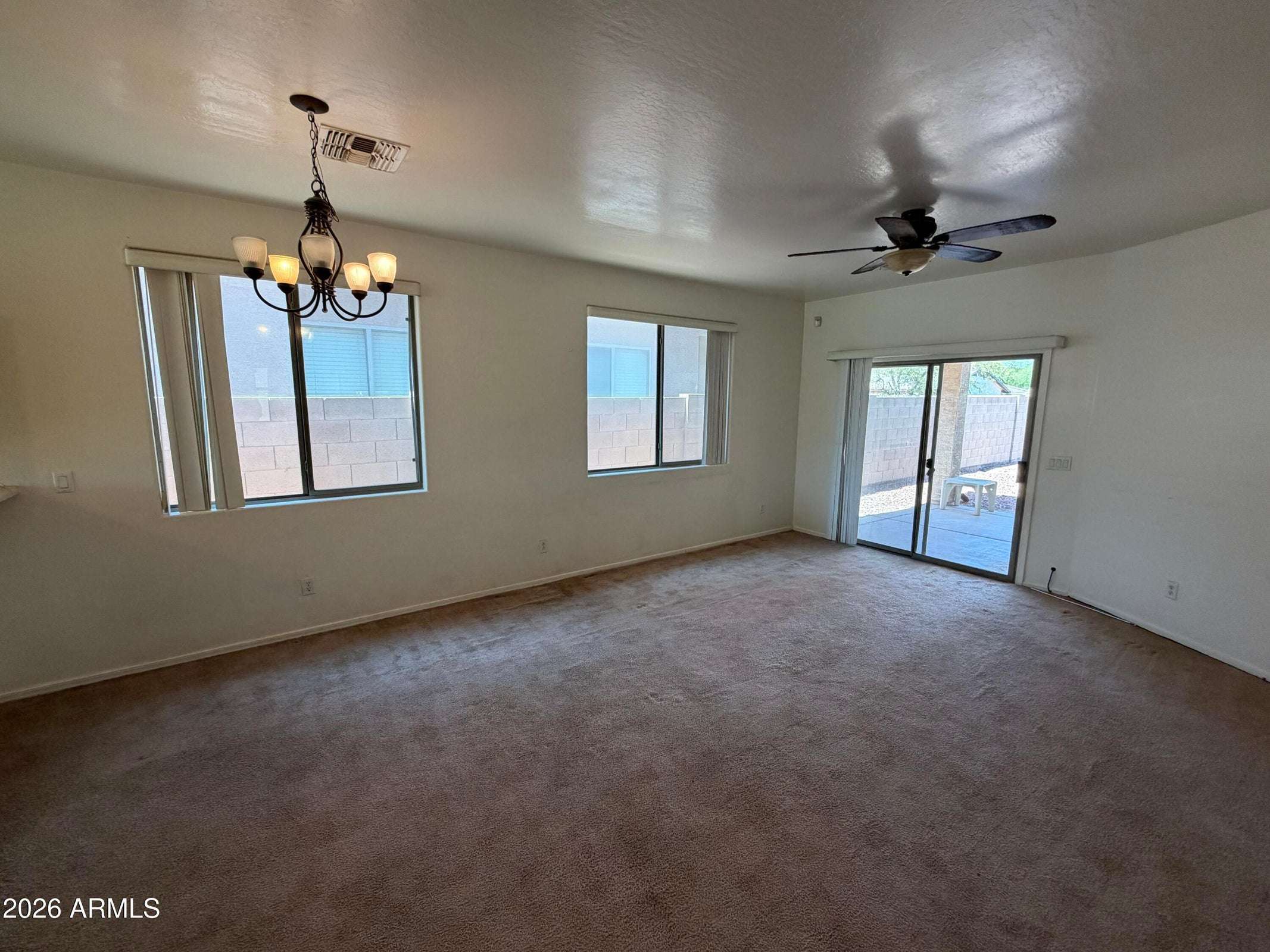 13 of 31. Large living room featuring expansive windows, ceiling fan, and patio access that creates a bright, airy atmosphere. Perfect for relaxing or hosting guests.