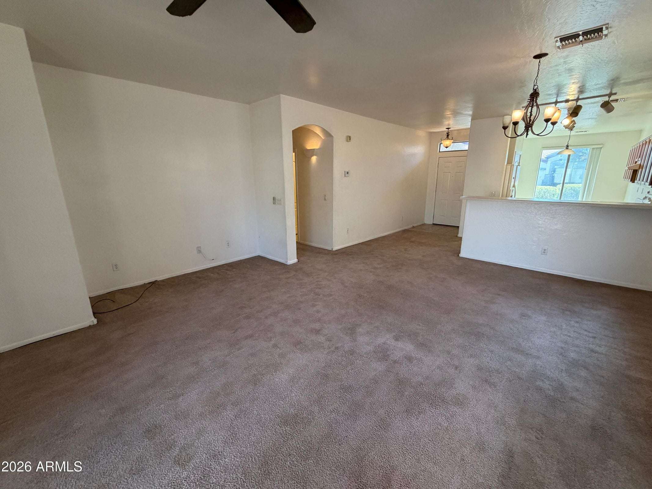 14 of 31. Open living room with breakfast bar, arched architectural details, and plenty of room for multiple furniture arrangements. Designed for comfortable everyday living.