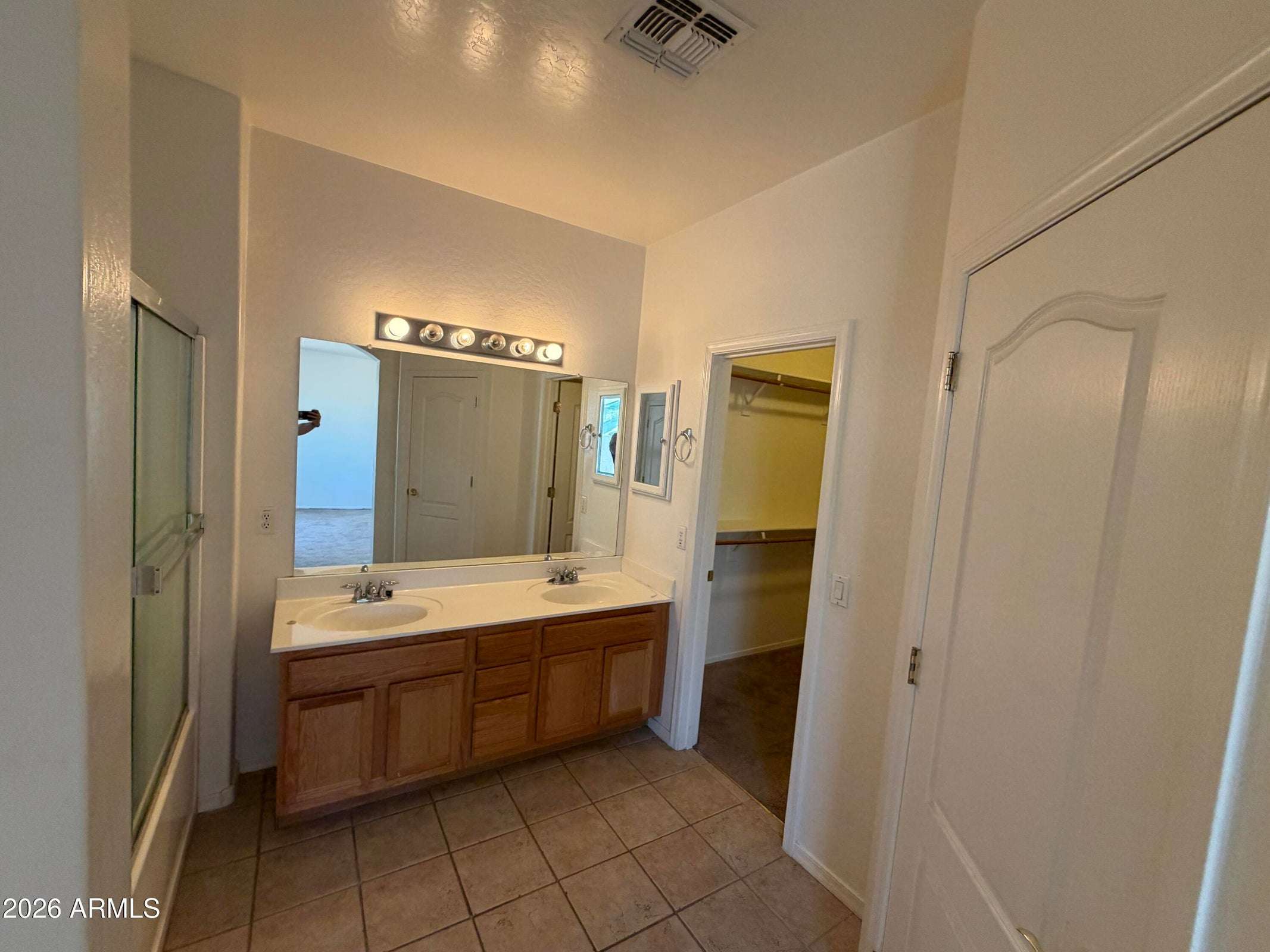 19 of 31. Primary bathroom with dual sinks, expansive vanity, walk-in closet access, and ample storage. Designed to provide convenience and functionality for everyday living.