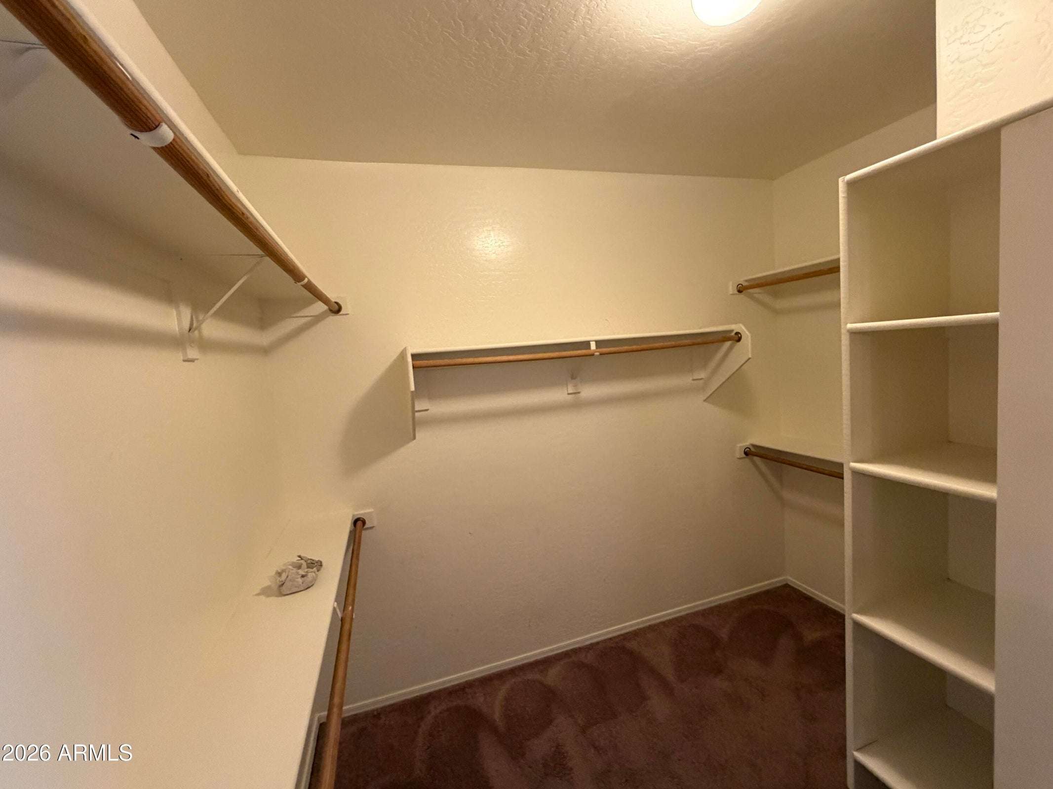 21 of 31. Expansive walk-in closet with built-in shelving, multiple hanging areas, and abundant storage to keep your wardrobe neatly organized in this Phoenix rental.