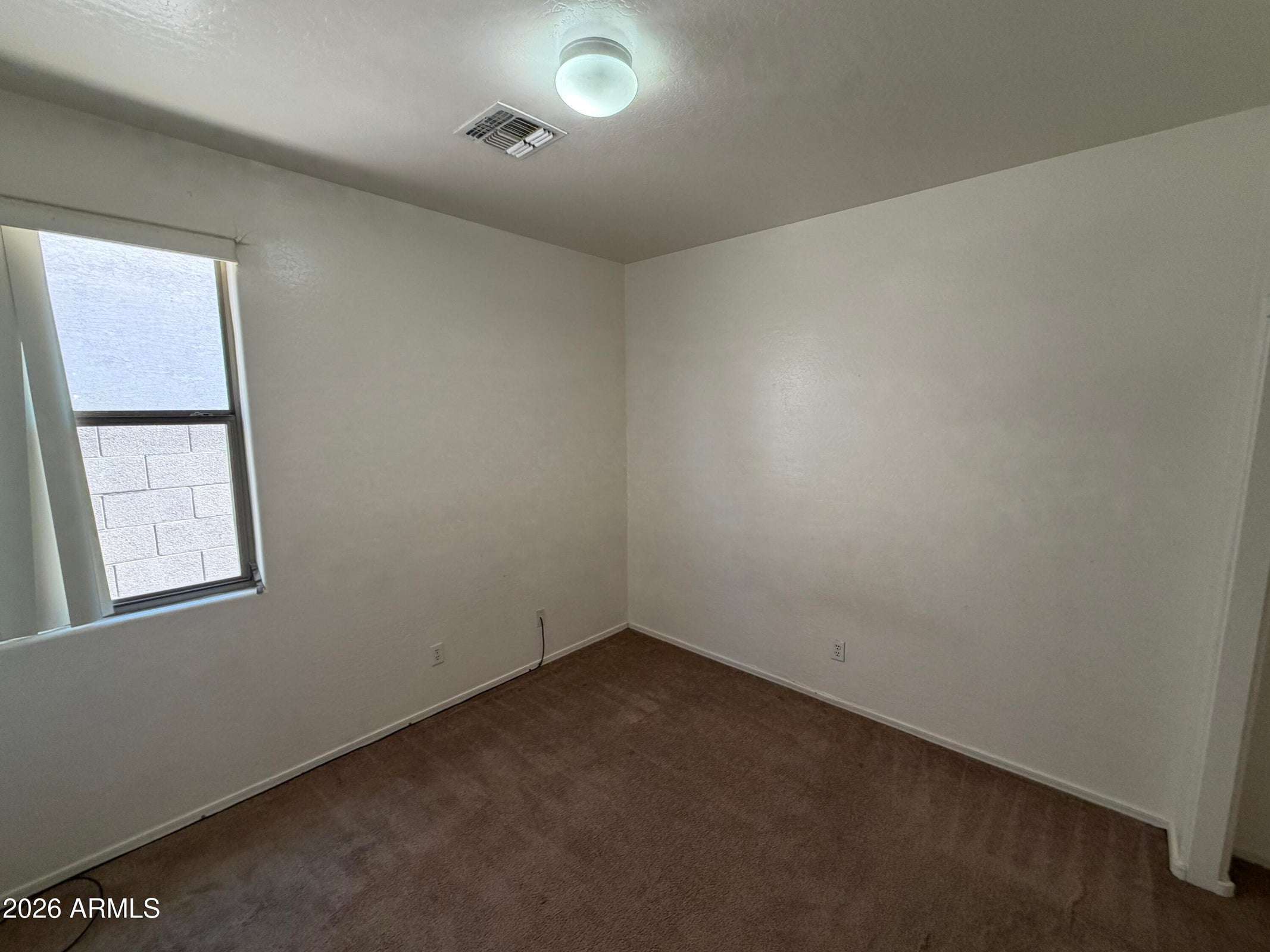 25 of 31. Inviting bedroom with neutral finishes, natural light, and plush carpeting, creating a comfortable space for guests or everyday living.