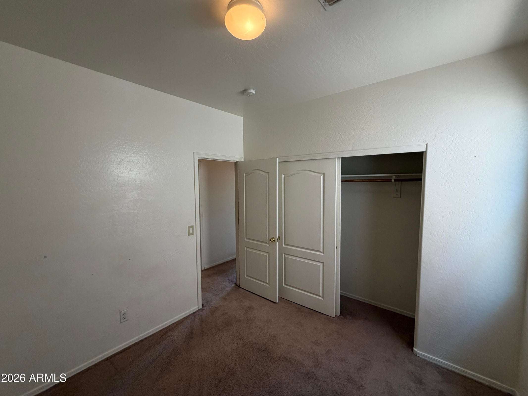26 of 31. Spacious bedroom with plush carpeting, large closet, and flexible floor plan suitable for a guest room, office, or personal retreat.
