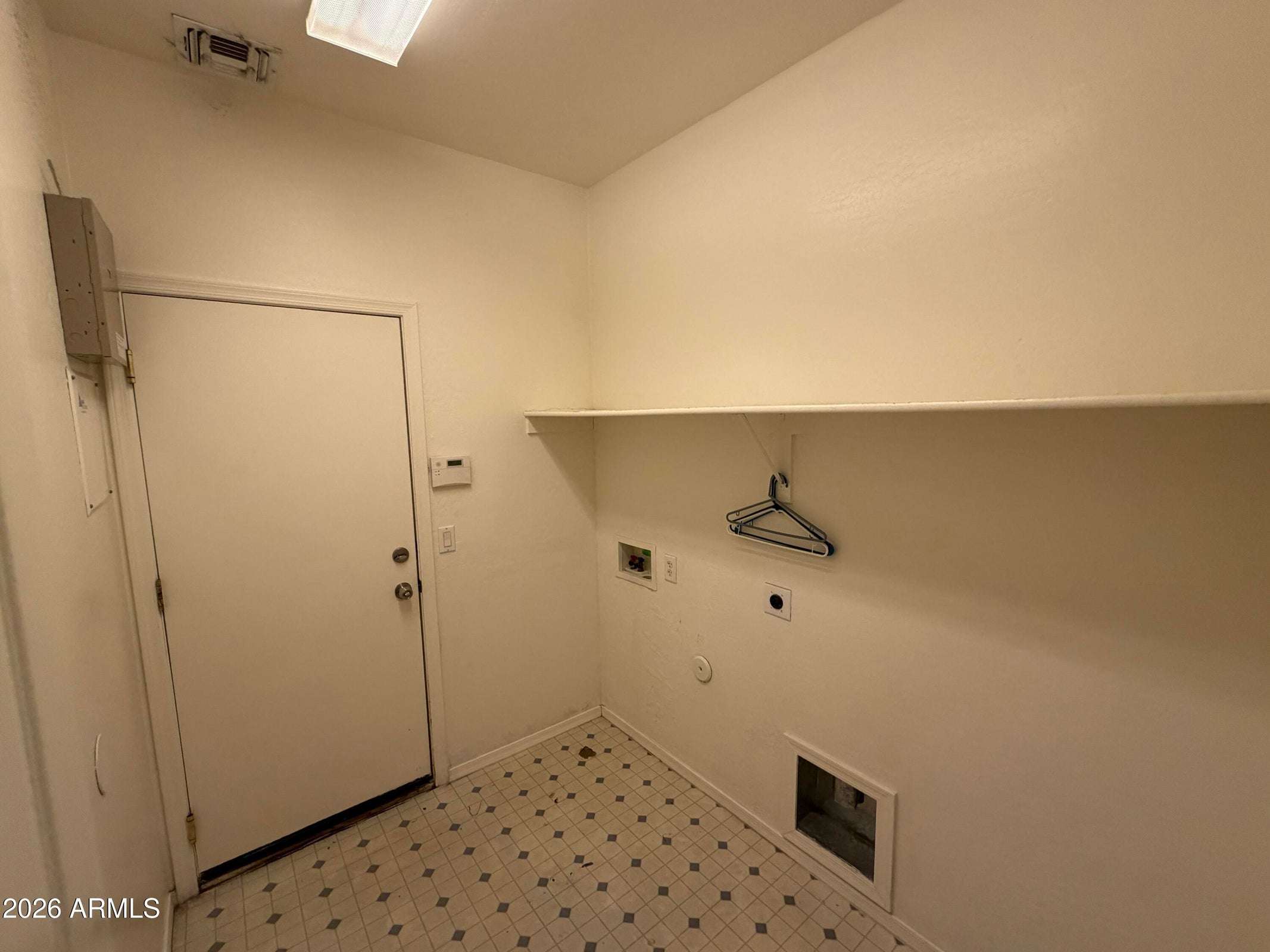 28 of 31. Dedicated laundry and utility room with washer and dryer hookups, storage shelf, and convenient access for efficient household tasks.