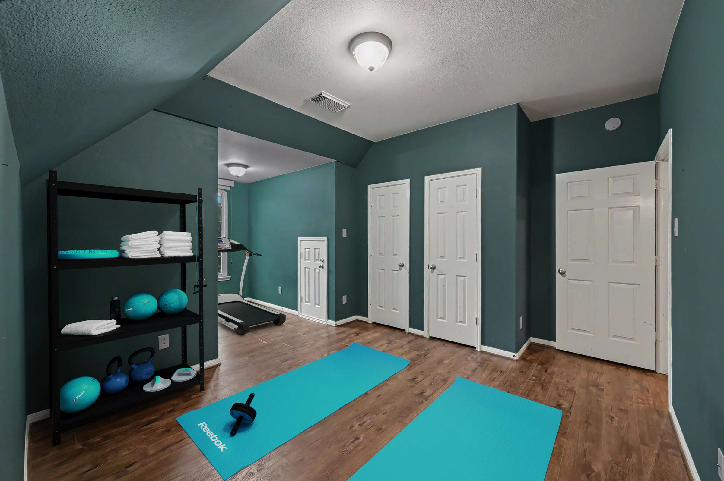 48 of 71. Discover a versatile workout space featuring ample storage and a treadmill, perfect for home fitness enthusiasts.