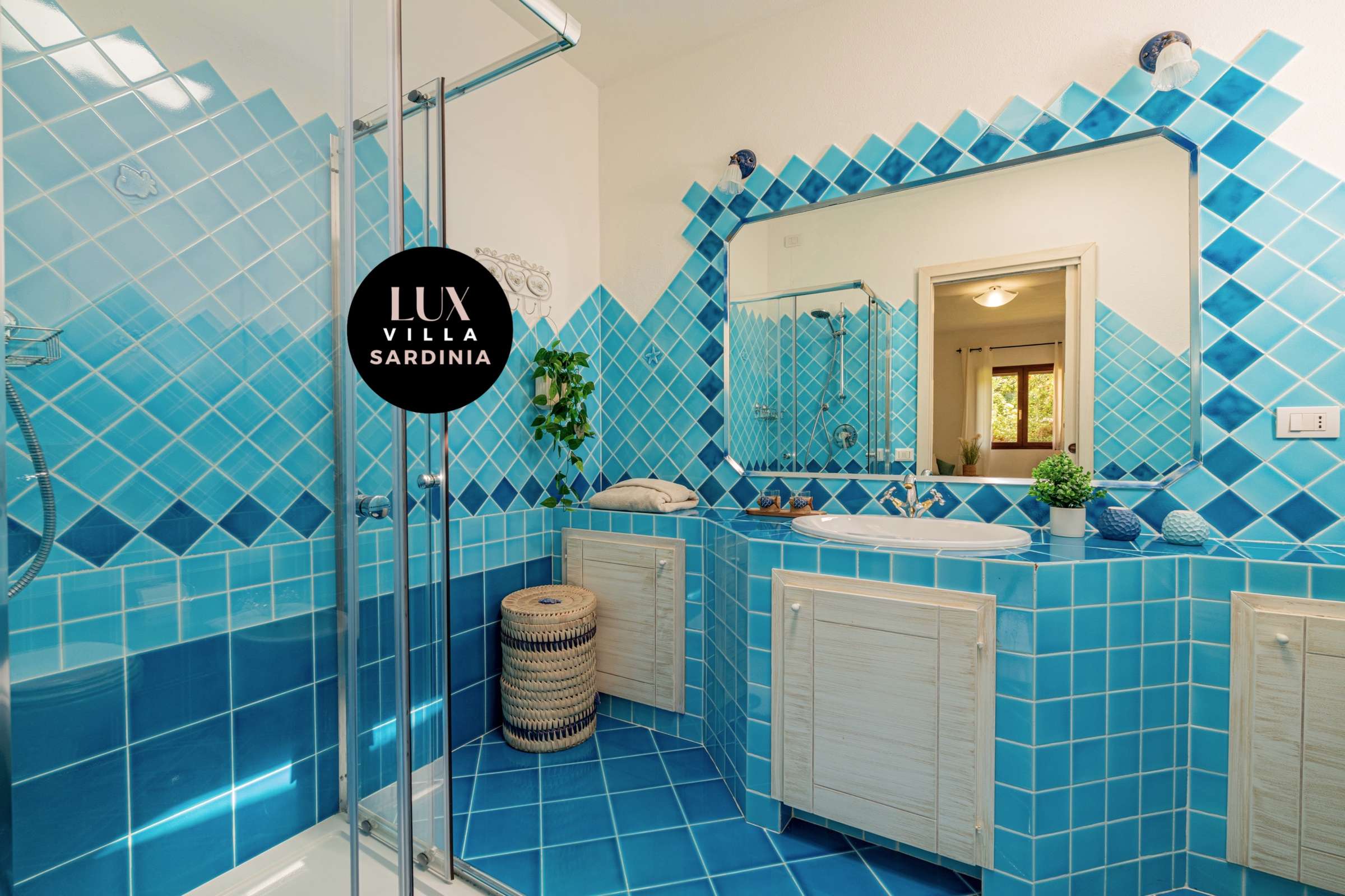 31 of 66. Bright and vibrant bathroom featuring unique blue tile work, modern fixtures, and natural light.