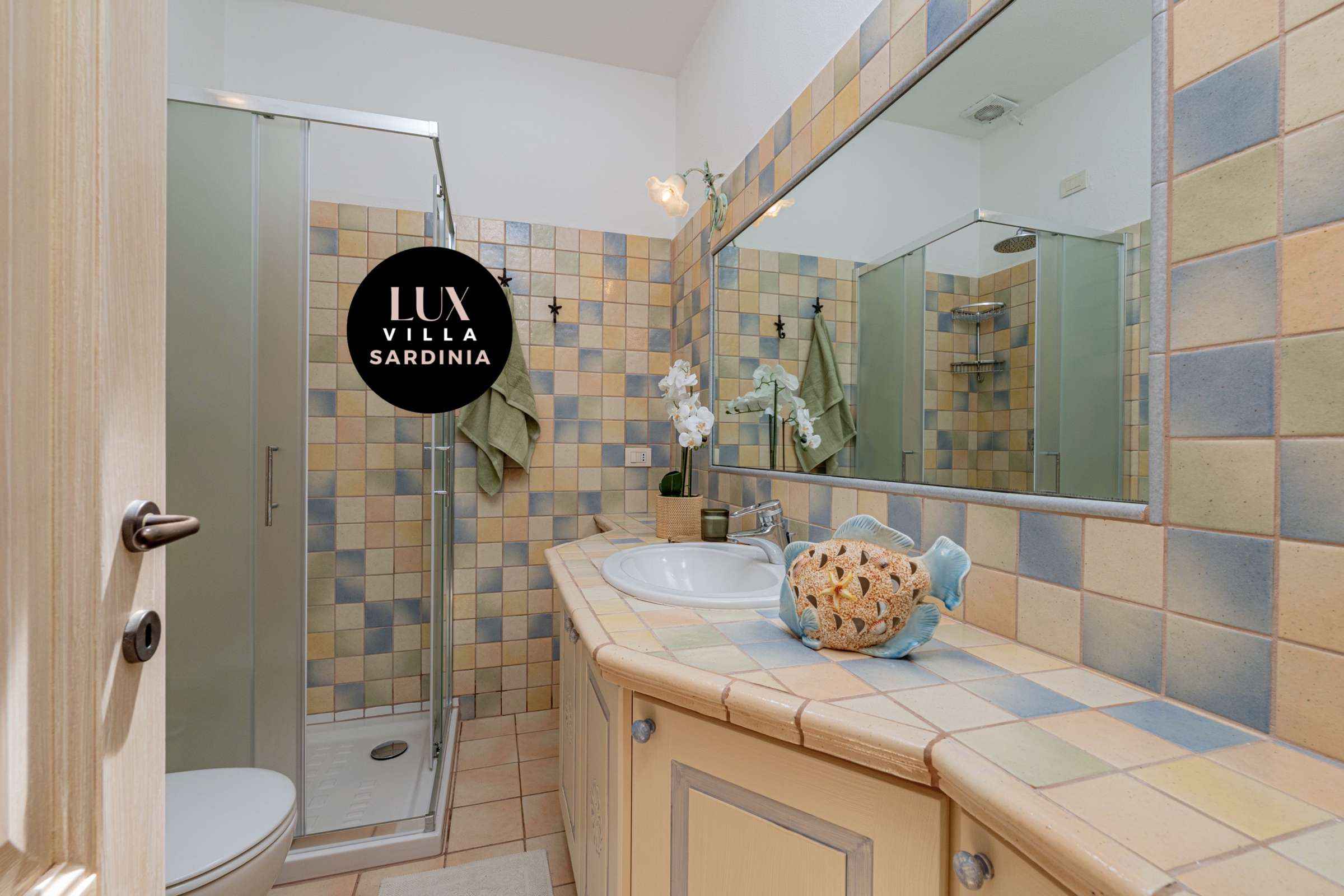 46 of 66. Bright bathroom featuring colorful tiled walls, modern fixtures, and ample natural light for a refreshing ambiance.