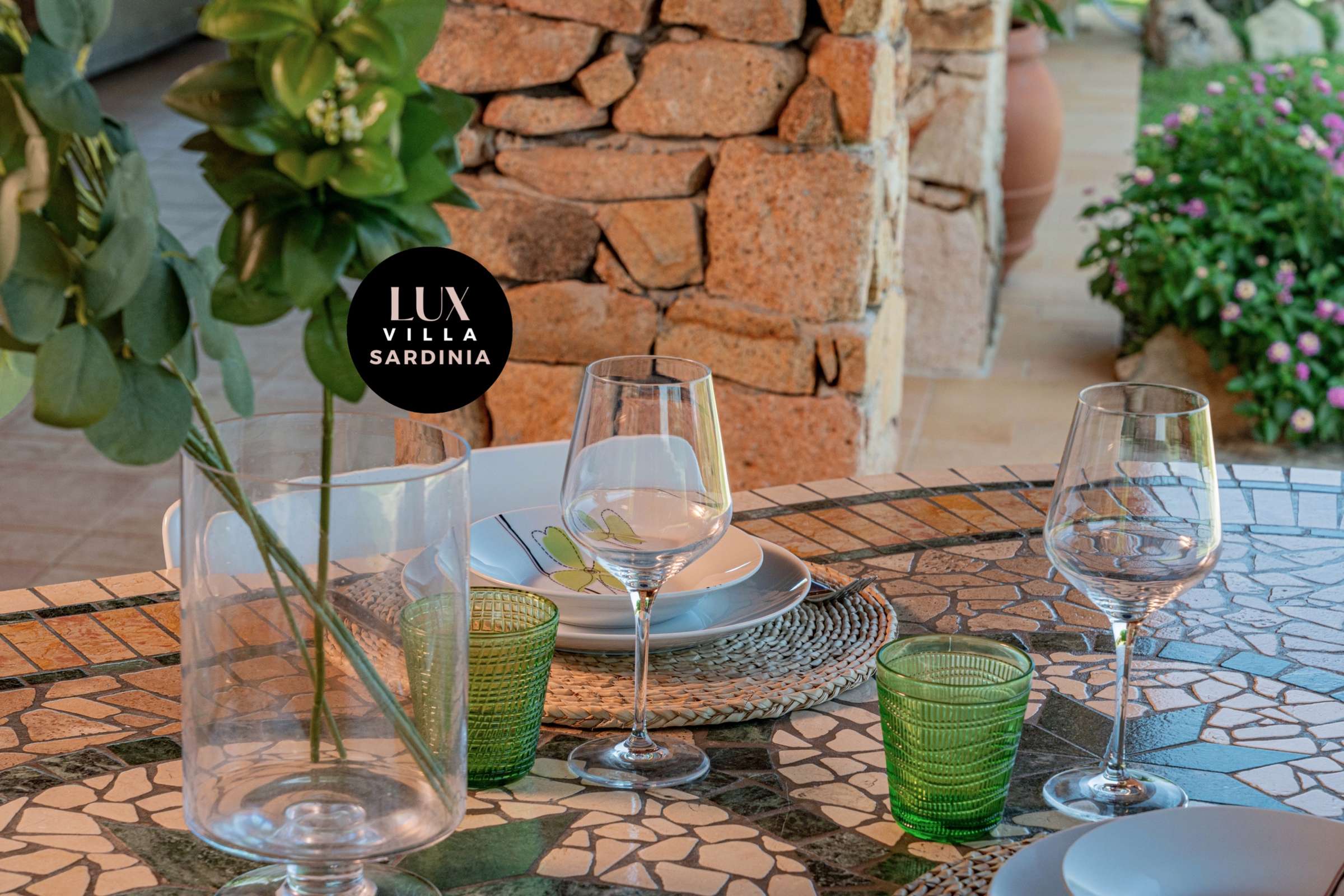 62 of 66. Discover a unique outdoor dining space, featuring mosaic tables and a lush, vibrant garden backdrop.