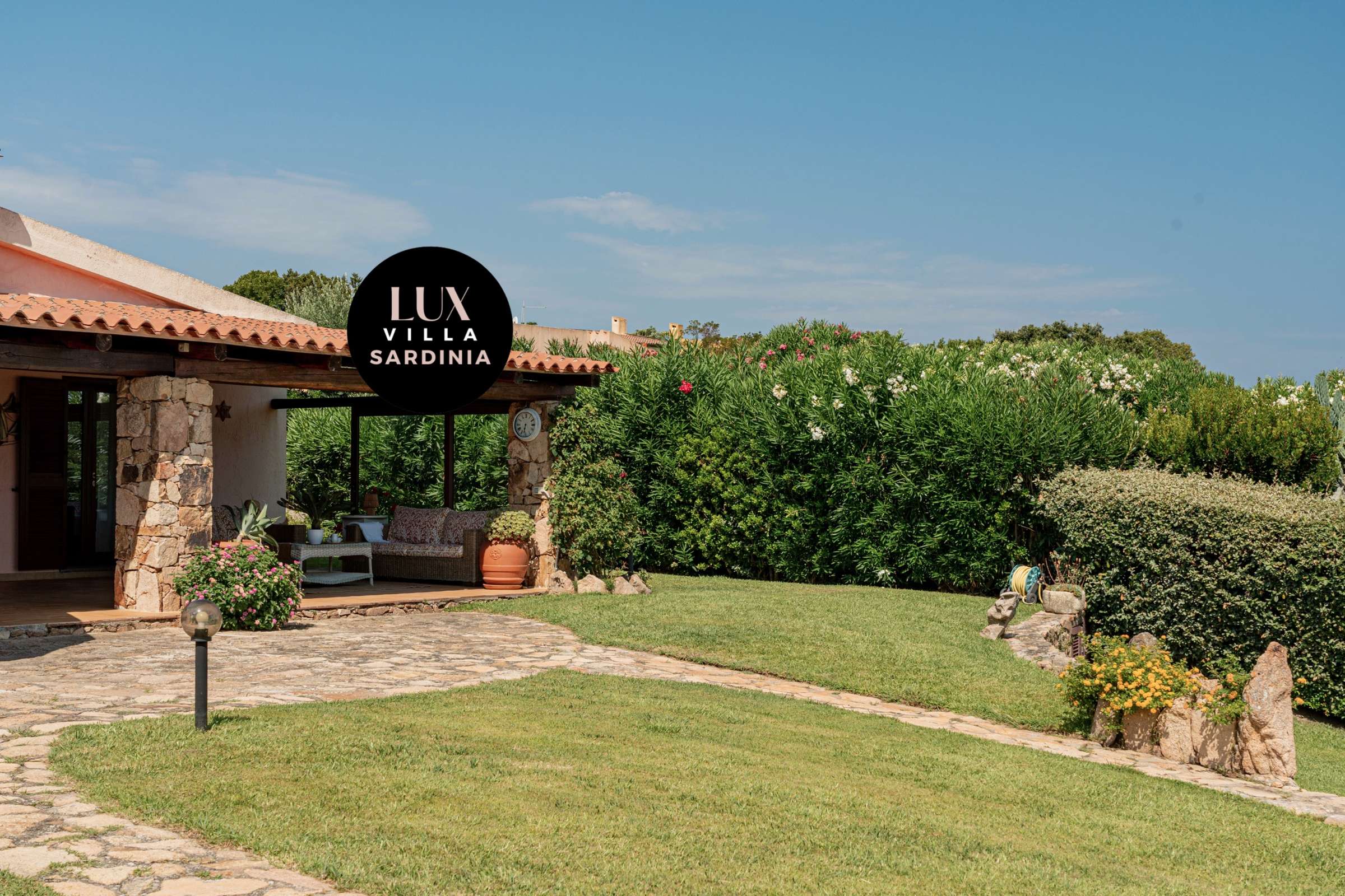 17 of 66. Discover this inviting villa in Sardinia, featuring lush gardens and a welcoming outdoor patio space.