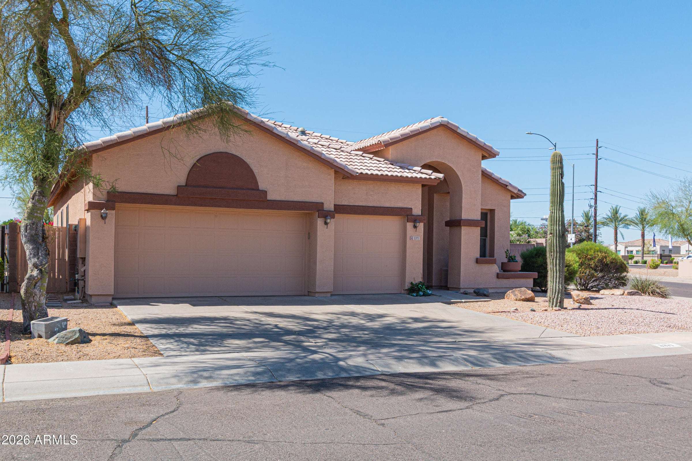2 of 29. Welcoming front fa ade featuring an arched entry, mature landscaping, and an oversized driveway leading to a three-car garage. A beautiful introduction to this spacious Terracina home.