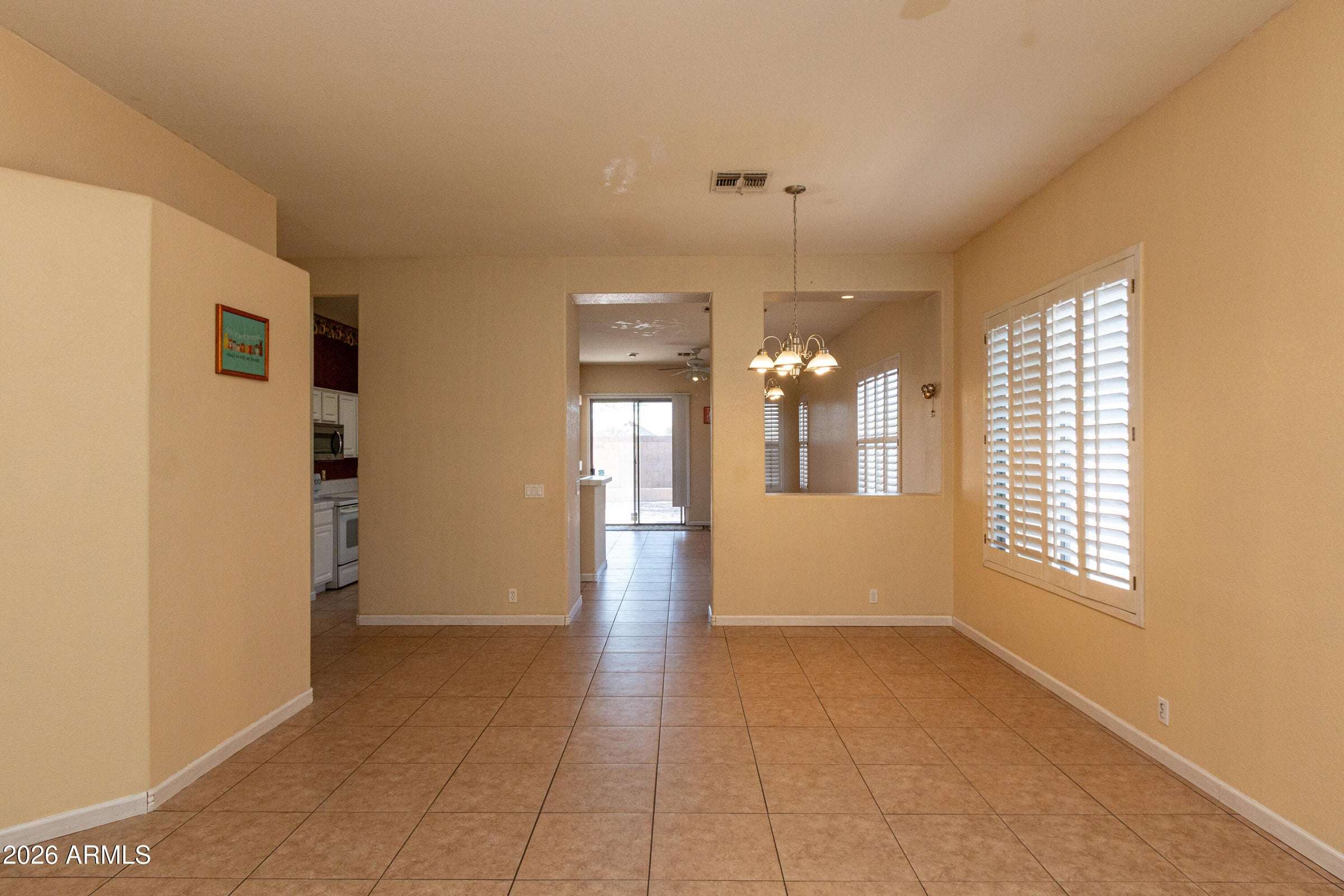 3 of 29. Generous living room with tile flooring and plantation shutters throughout. This versatile area offers endless possibilities for formal entertaining, a sitting room, or additional family gathering space.