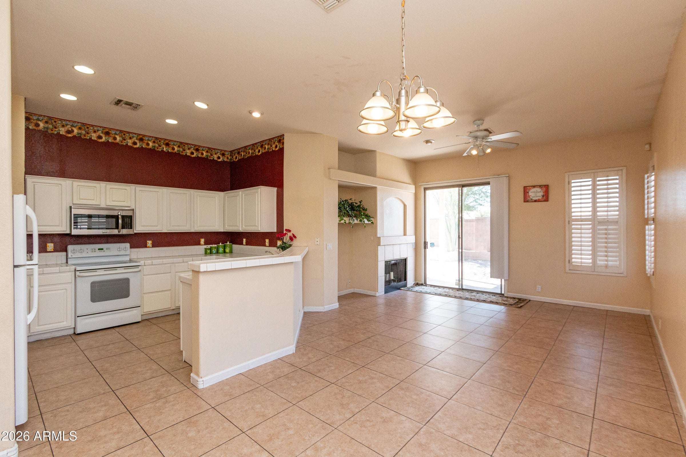 6 of 29. Open kitchen overlooking the family room with breakfast bar seating, abundant storage, and recessed lighting. The seamless design encourages conversation and connection while entertaining.