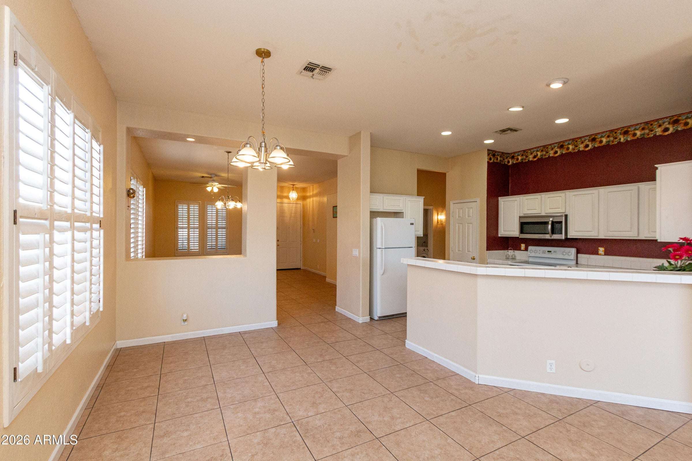 9 of 29. Well-appointed kitchen with abundant cabinetry, breakfast bar, tile counters, and convenient workspace. The open design keeps the kitchen connected to the home's main living spaces.