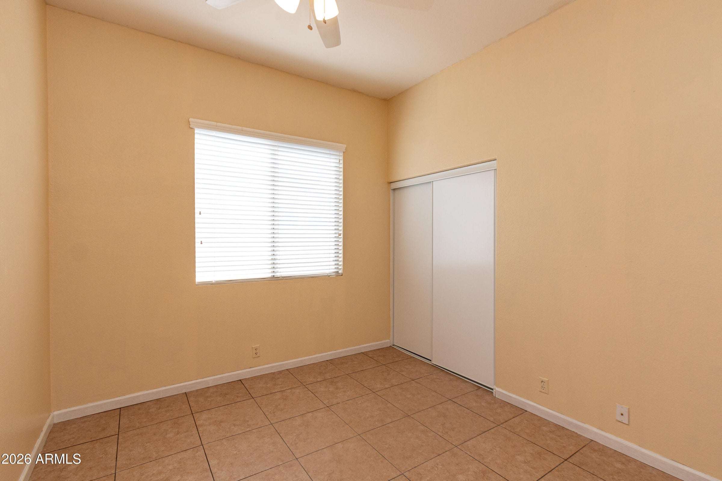 20 of 29. Bright guest bedroom featuring closet storage, tile flooring, and a large window. A flexible space that adapts easily to changing household needs.