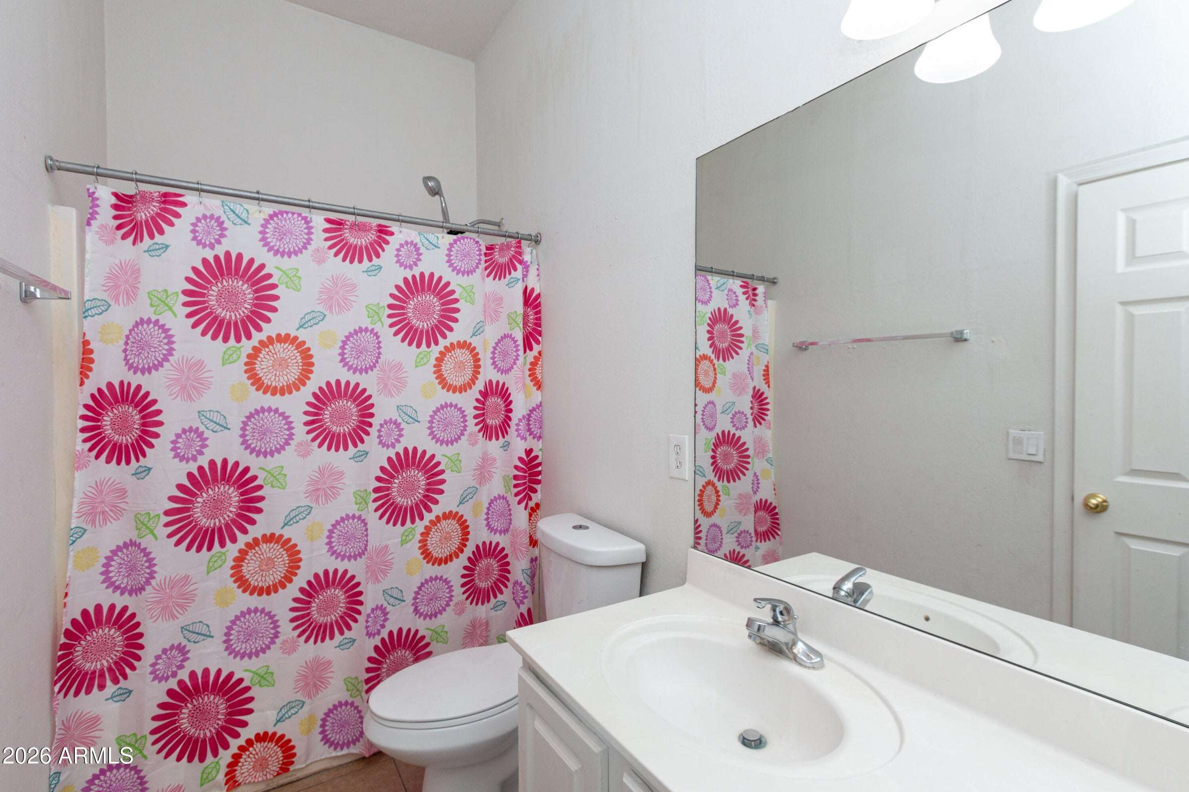 22 of 29. Bright hall bathroom featuring a spacious vanity, large mirror, and full tub-shower setup. A practical and comfortable space designed to accommodate guests and daily living needs.
