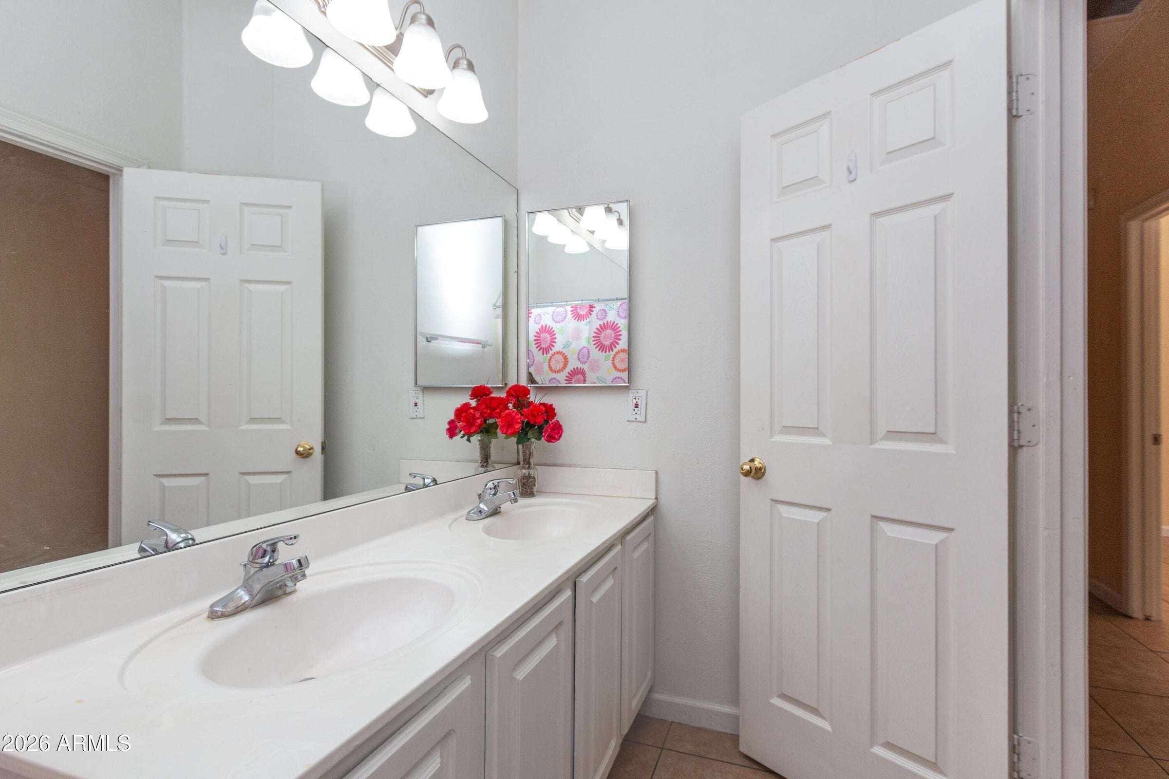 23 of 29. Well-appointed bathroom showcasing dual sinks, generous counter space, and updated lighting. The functional layout offers convenience for busy households and visiting guests.