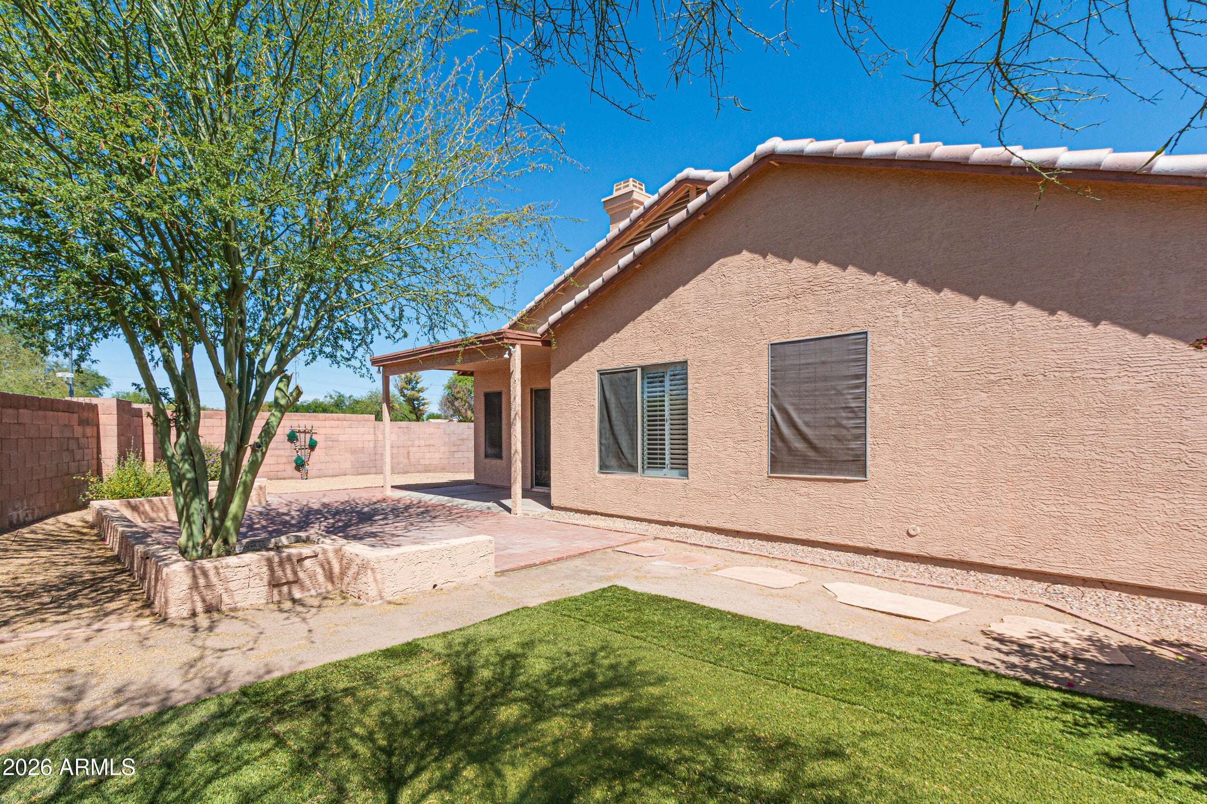 26 of 29. Private backyard featuring mature trees, easy-care landscaping, and a covered patio area. The outdoor setting offers room to relax, entertain, and enjoy the Arizona lifestyle.