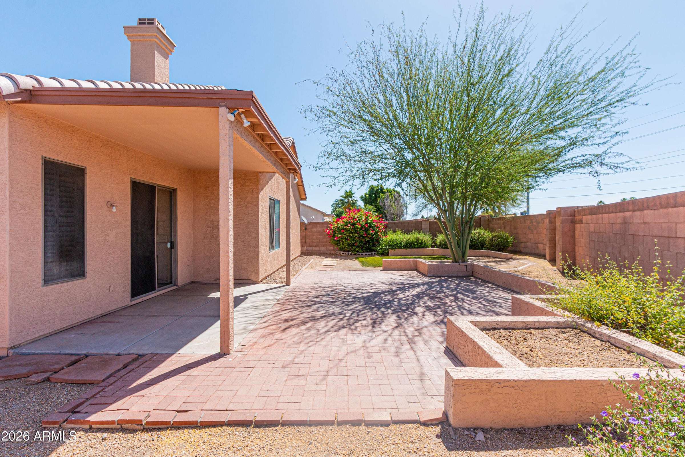 28 of 29. Attractive backyard with desert landscaping, mature shade trees, and generous patio space. Designed for low-maintenance living while maximizing outdoor enjoyment.