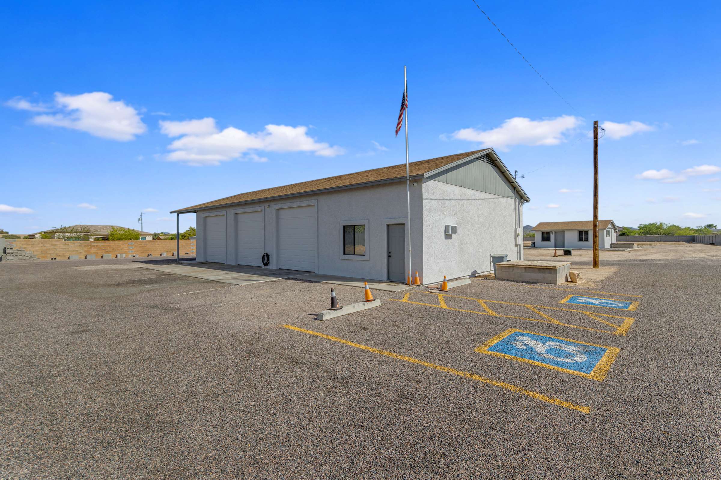 38 of 43. Exceptional detached workshop offering oversized bay doors, extensive paved parking, covered workspace, and professional-grade features including 220V power and a dedicated electric meter. Perfect for collectors, contractors, or entrepreneurs.