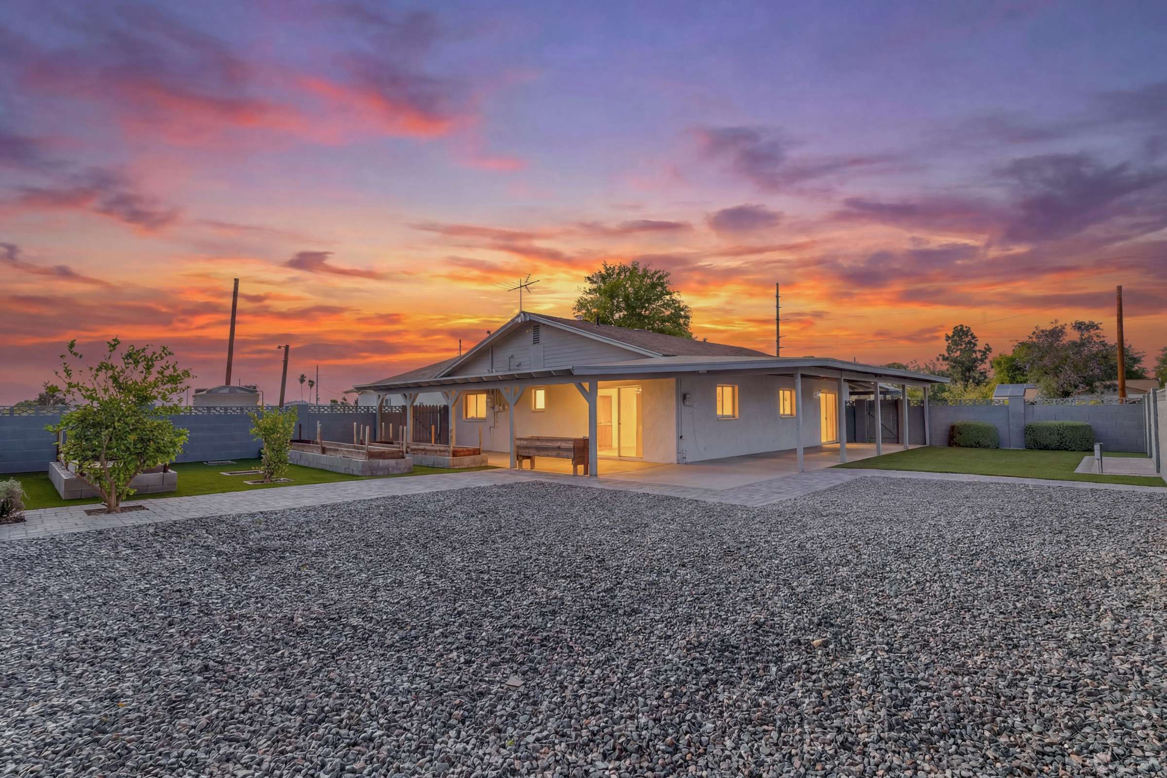 2 of 43. Spacious backyard with an oversized covered patio, mature landscaping, citrus trees, and ample room for entertaining or future outdoor enhancements. Enjoy privacy and open space on this generous Goodyear property.