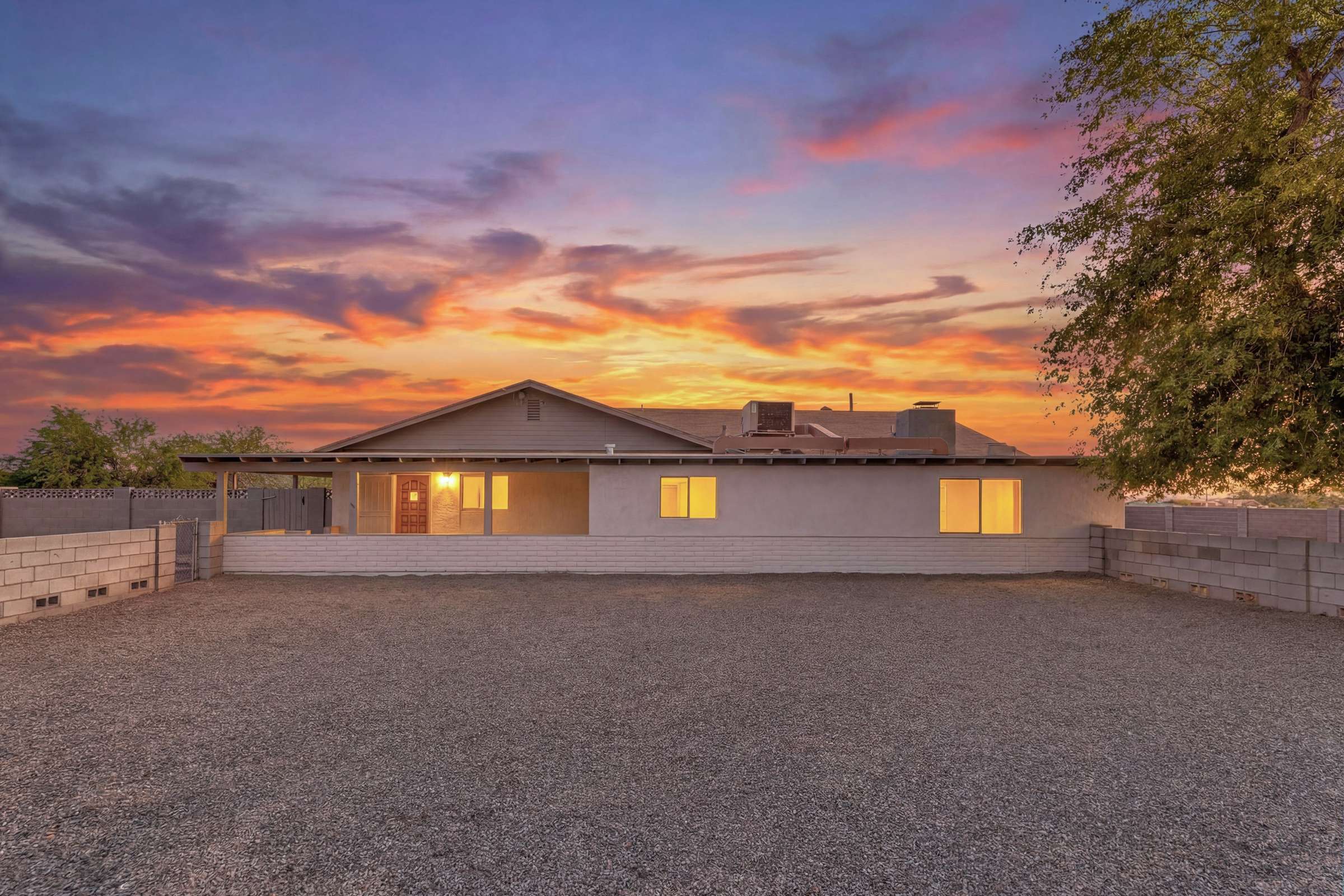 1 of 43. Beautiful front elevation showcasing the home's spacious lot, mature trees, and expansive grounds. Enjoy exceptional privacy and flexibility with over two acres of usable land in Goodyear.