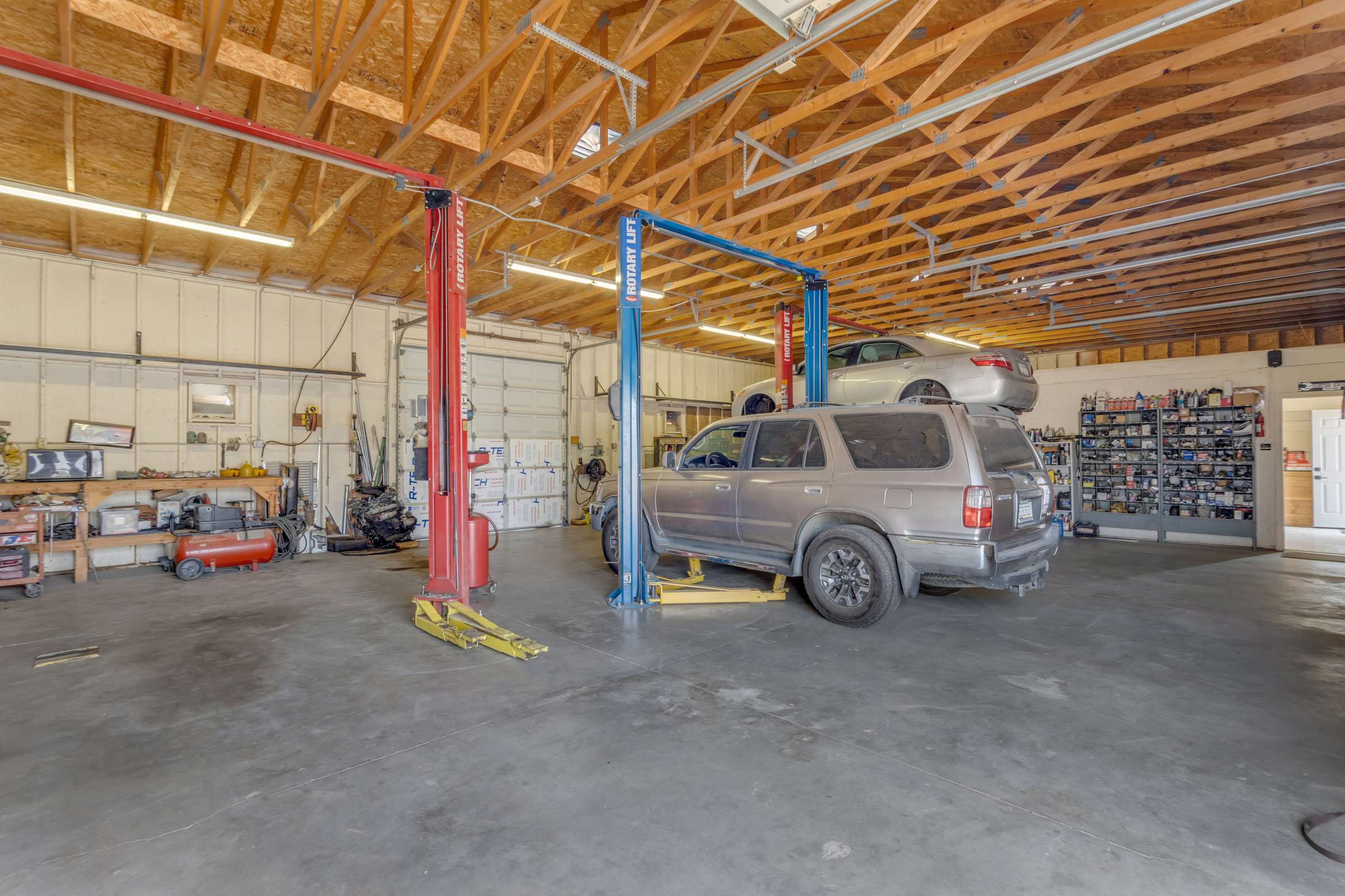 10 of 43. Spacious detached garage features automotive lifts, high ceilings, oversized work areas, and room for multiple vehicles, making it ideal for collectors, mechanics, business owners, or hobby enthusiasts in Goodyear.