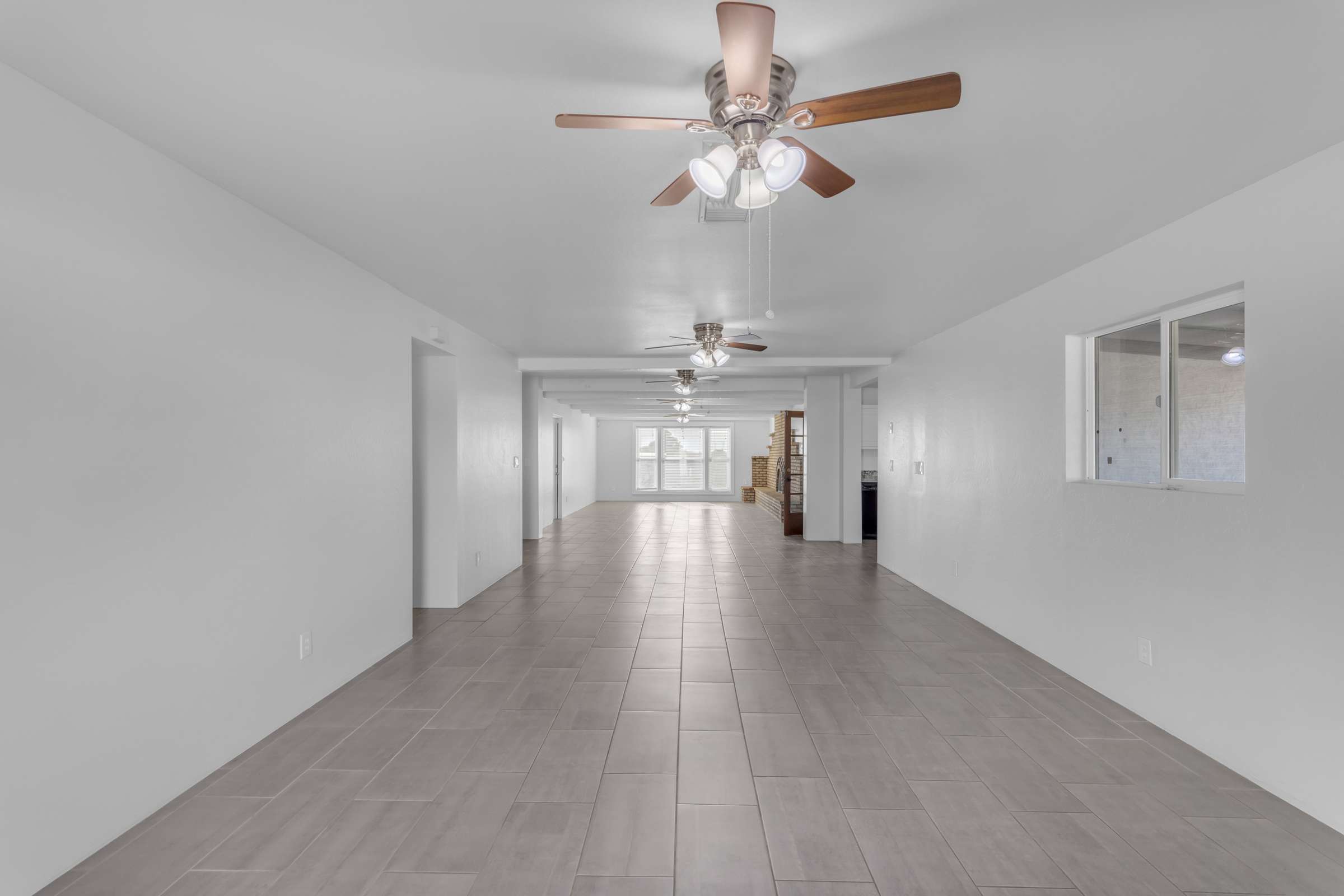 17 of 43. Large open-concept living area provides endless furniture arrangement possibilities with updated flooring, multiple ceiling fans, and generous natural light throughout the home.