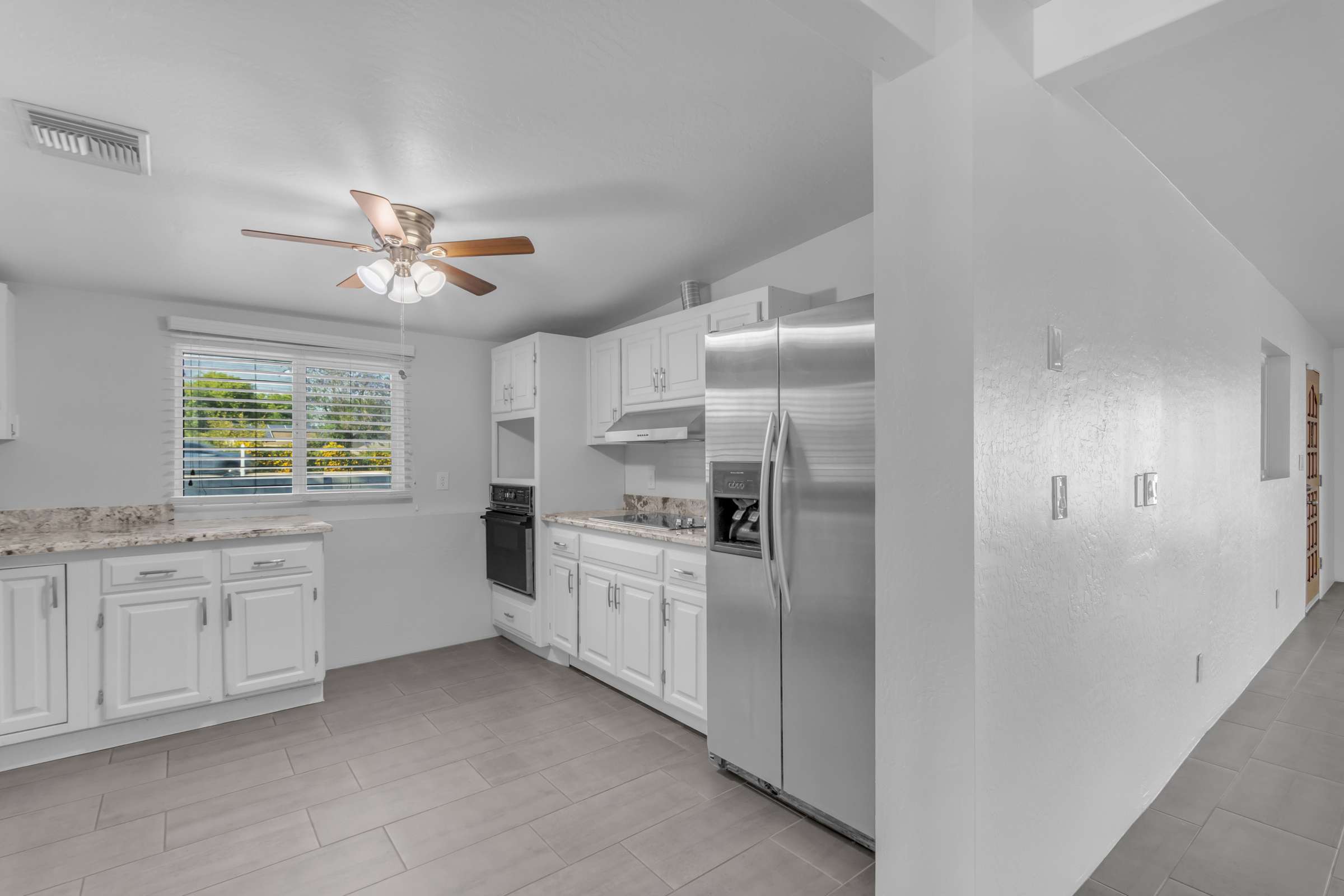21 of 43. Updated kitchen offers granite countertops, stainless steel appliances, white cabinetry, and an efficient layout with ample workspace, creating a bright and welcoming heart of the home.