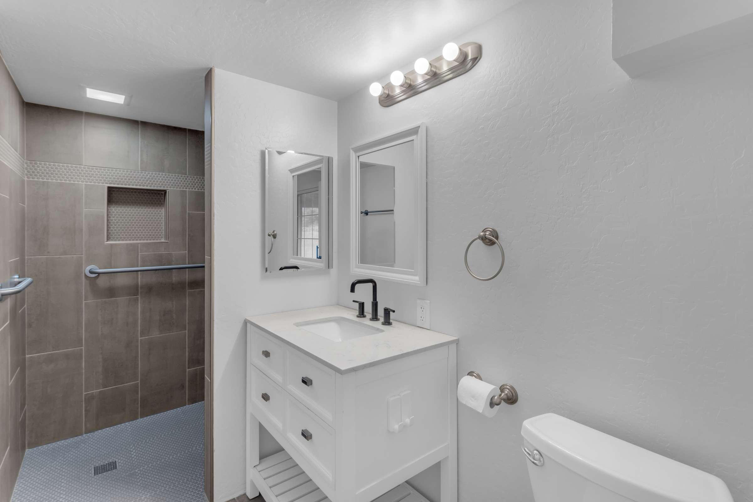 26 of 43. Elegant remodeled bathroom features an oversized tiled shower with built-in storage niche, updated vanity, modern fixtures, and stylish finishes designed for lasting appeal.