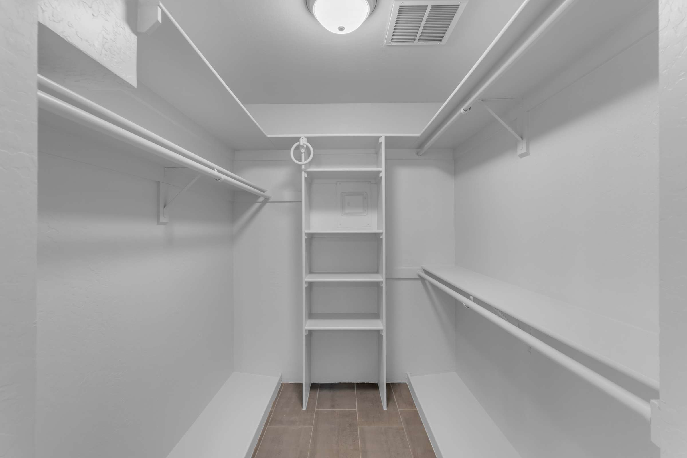 27 of 43. Large walk-in closet provides built-in shelving, multiple hanging sections, and generous storage space to help keep wardrobes neatly organized and easily accessible.