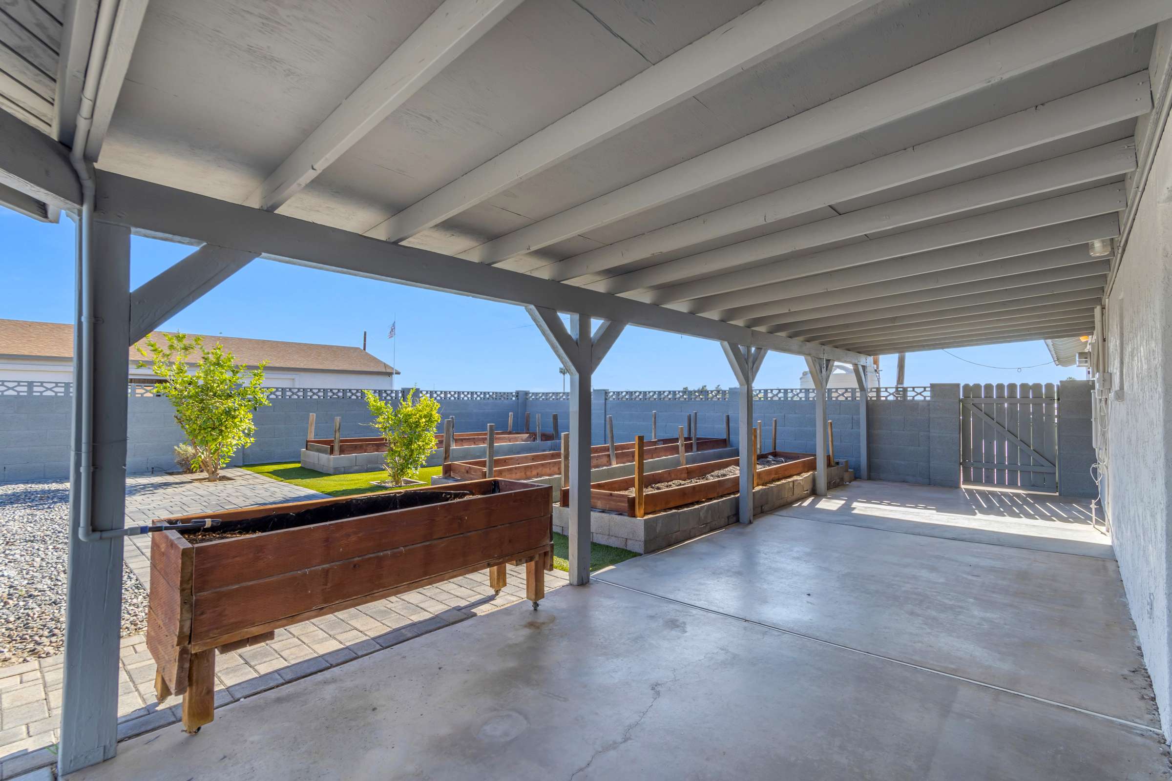 28 of 43. Relax beneath the covered patio while enjoying raised garden beds, attractive paver walkways, and low-maintenance landscaping that creates a welcoming outdoor living environment.