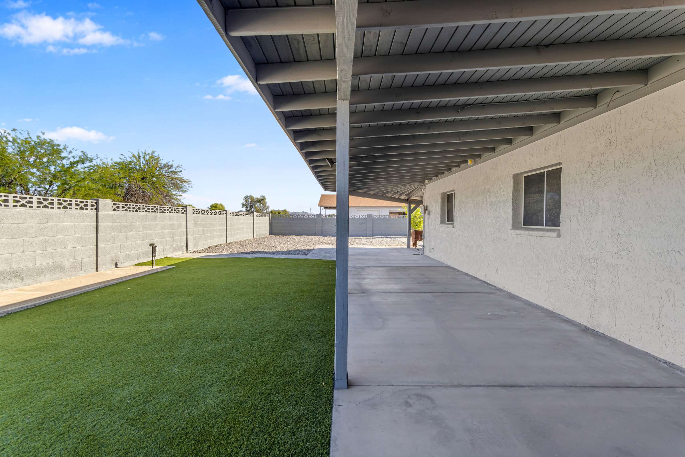 35 of 43. Expansive covered patio complements the spacious backyard with artificial turf and easy-care landscaping, providing a comfortable extension of the home's living space.