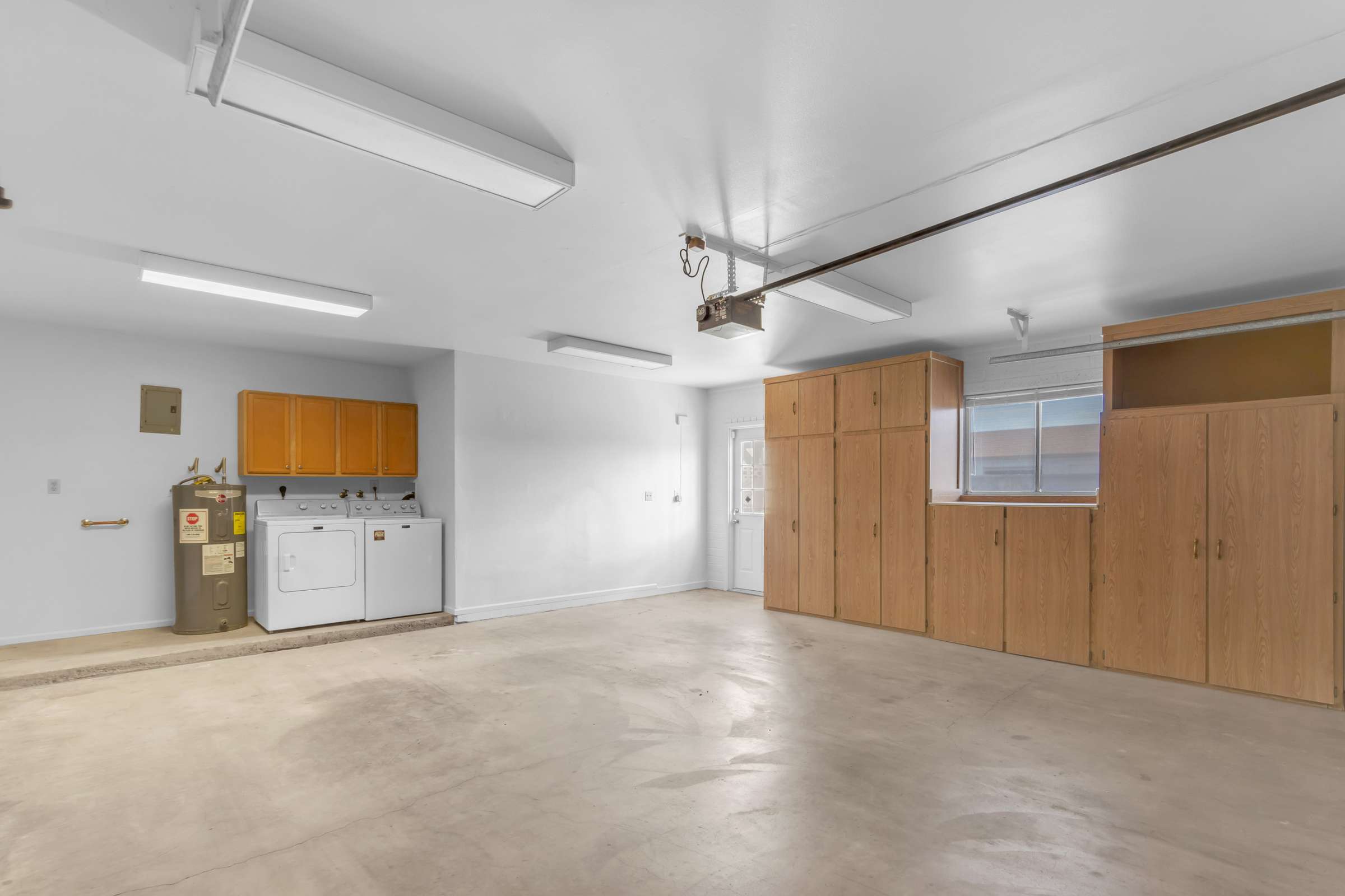 36 of 43. Functional oversized garage features built-in cabinets, laundry hookups, extra storage, and plenty of room for vehicles, tools, and workshop space.