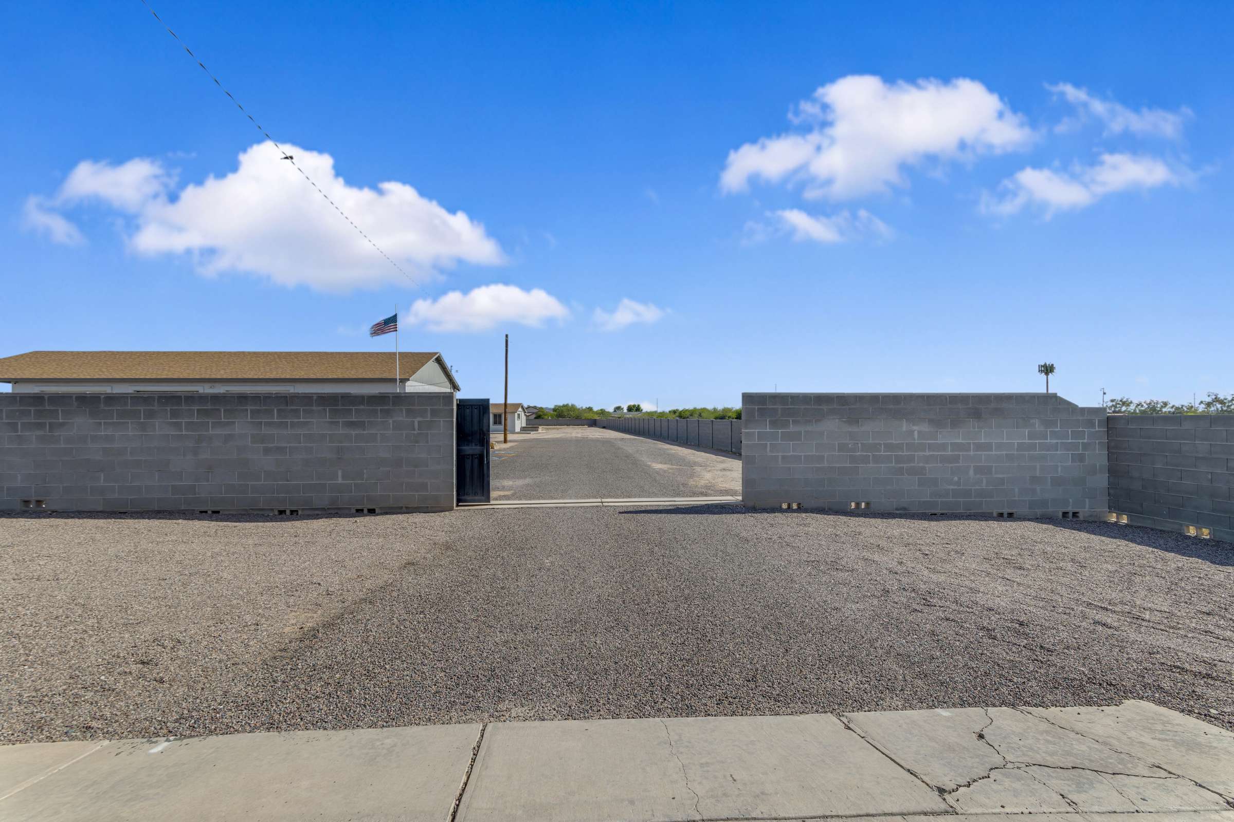 41 of 43. Spacious gated entrance provides secure access to the fully enclosed property with room for RVs, trailers, work vehicles, and additional parking while enhancing privacy in Goodyear.