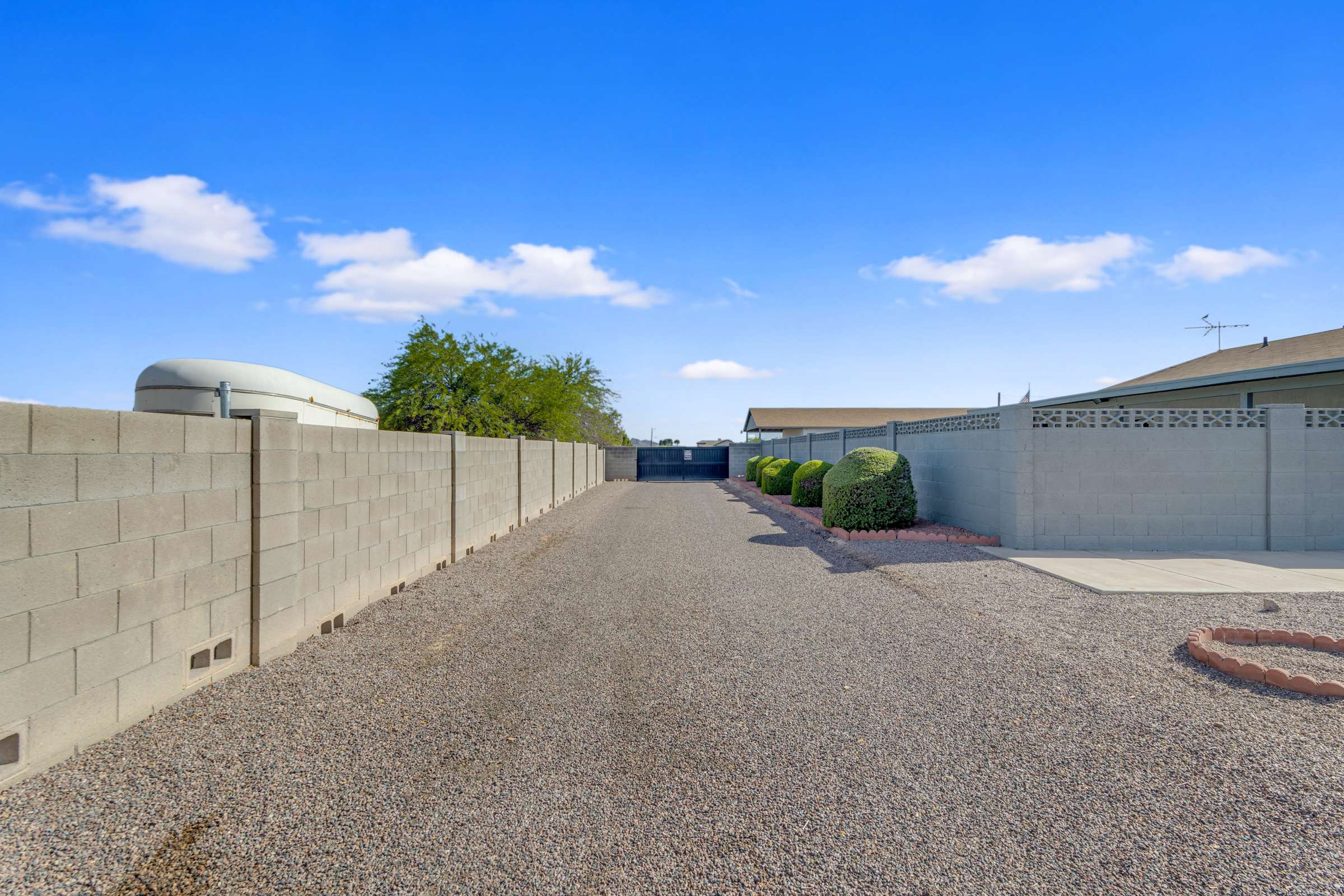 43 of 43. Long gravel driveway offers outstanding space for RV parking, trailers, boats, and guest vehicles while providing easy access through the gated entrance.