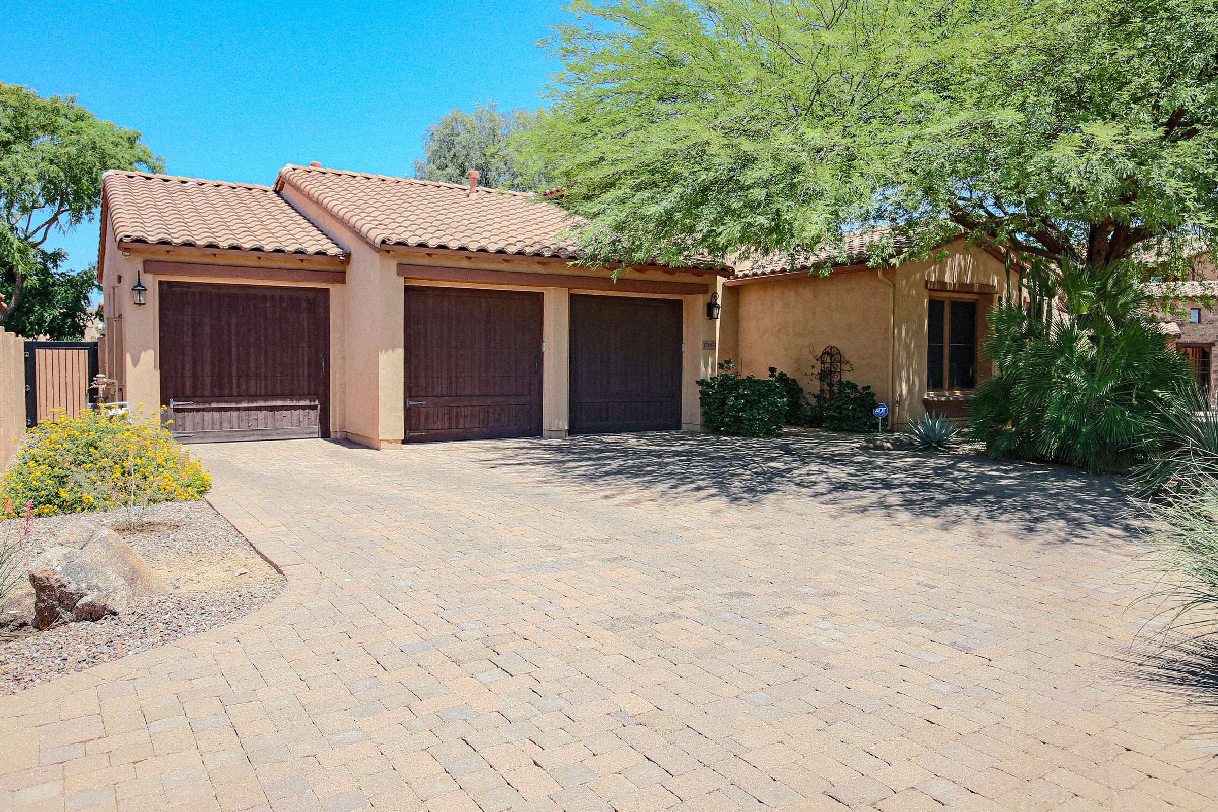 8 of 72. An oversized 3.5-car garage, generous paver driveway, gated access, and mature desert landscaping create a striking first impression while providing outstanding parking and storage.