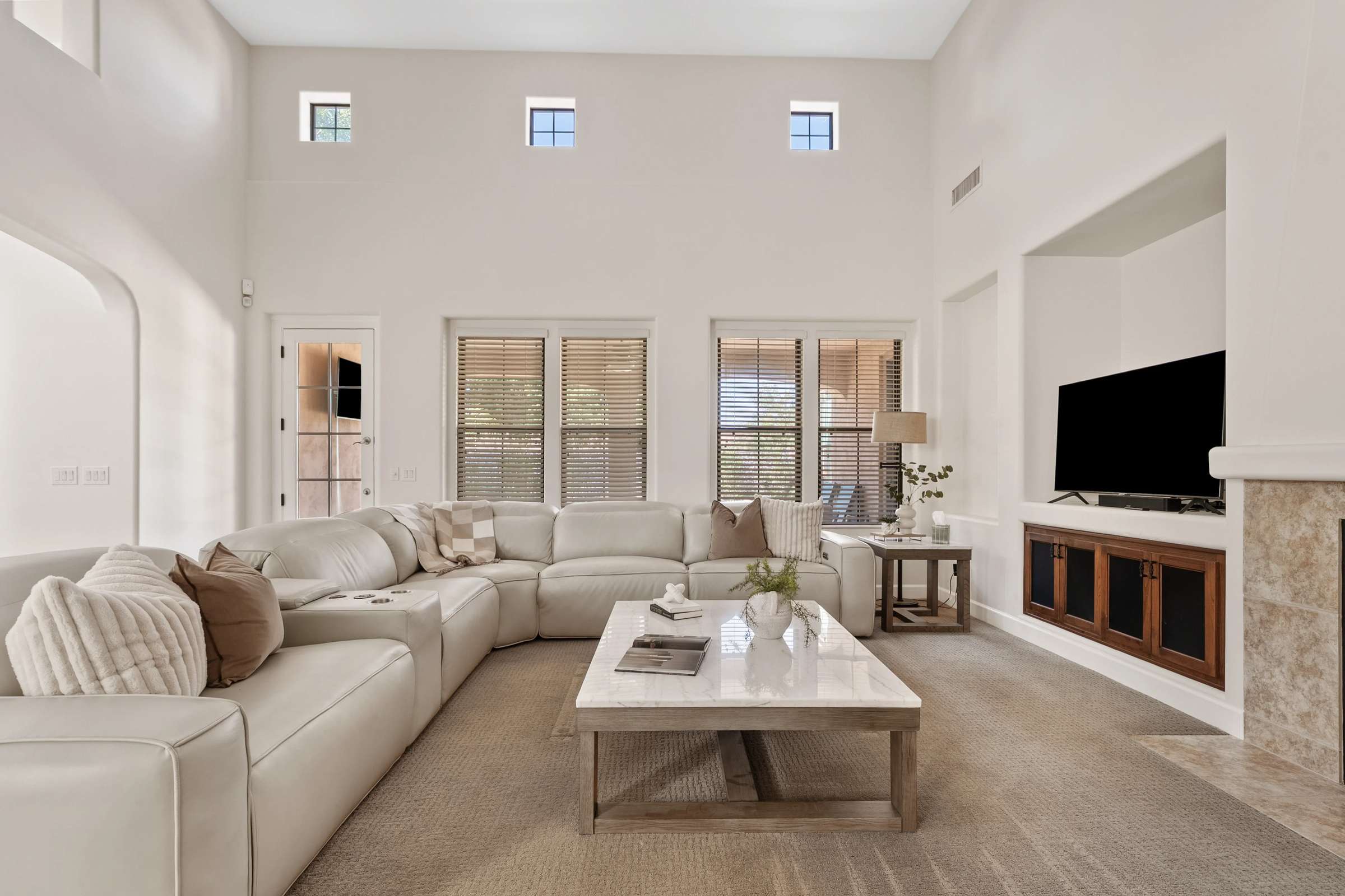 11 of 72. Gather beneath soaring ceilings in this spacious family room featuring a fireplace, built-in entertainment center, and abundant natural light. The open-concept design is ideal for everyday living and entertaining.