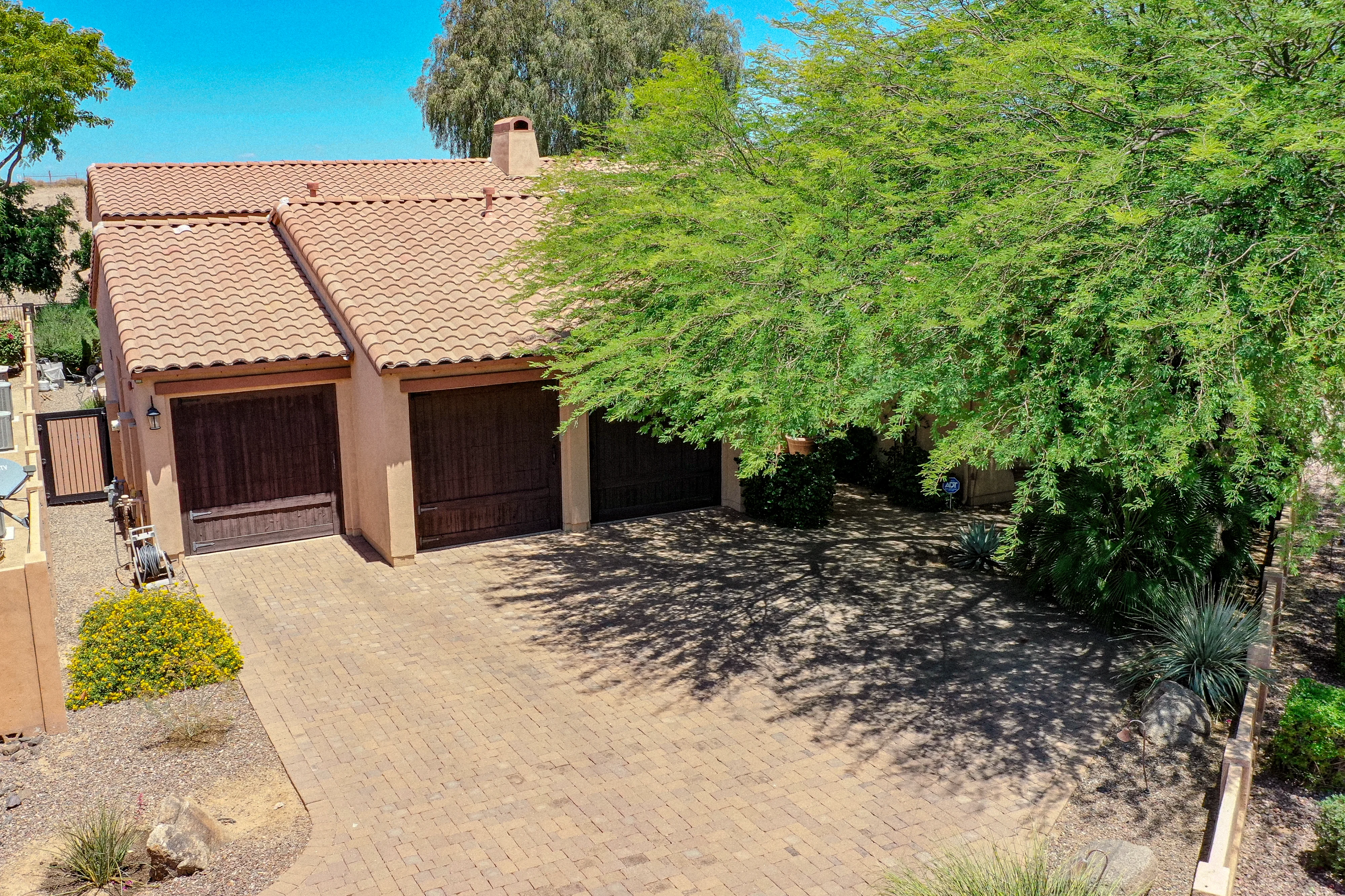 71 of 72. This aerial front view emphasizes the generous paver driveway, three-car garage, mature shade tree, and attractive desert landscaping that enhance the curb appeal of this beautifully maintained Scottsdale home.