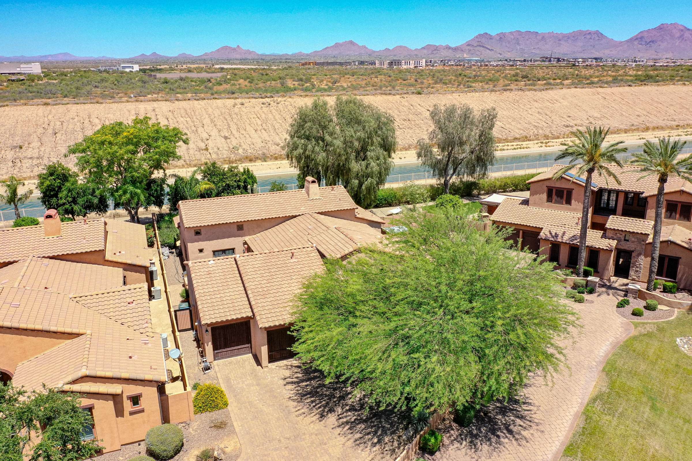 72 of 72. An expansive aerial image highlights the surrounding Scottsdale community, nearby mountain vistas, mature trees, and the home's prime location. The view showcases an inviting neighborhood with attractive homes and scenic desert surroundings.