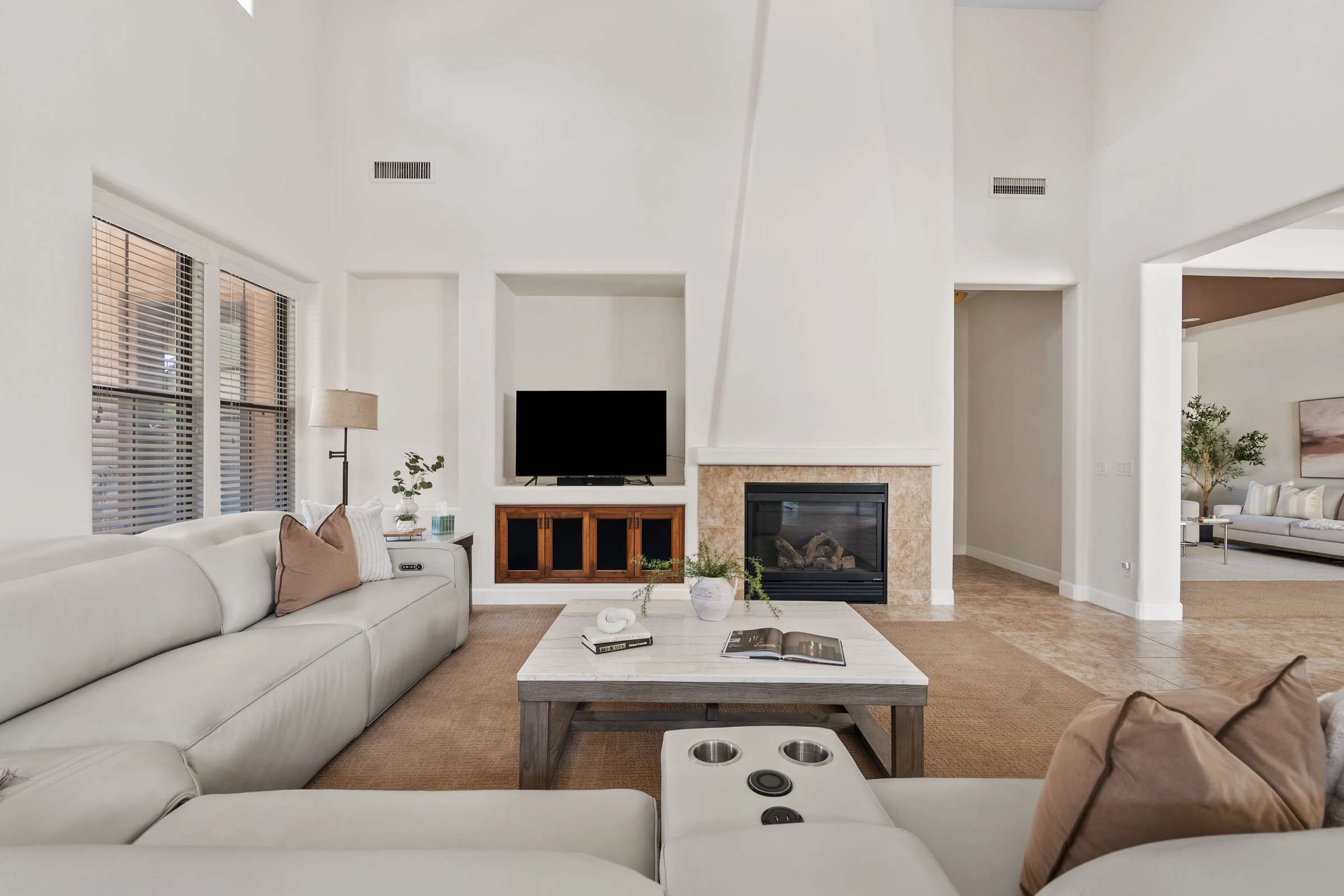 4 of 72. Gather in the spacious family room with soaring ceilings, a cozy fireplace, built-in media center, and an open layout that enhances both comfort and functionality throughout the home.