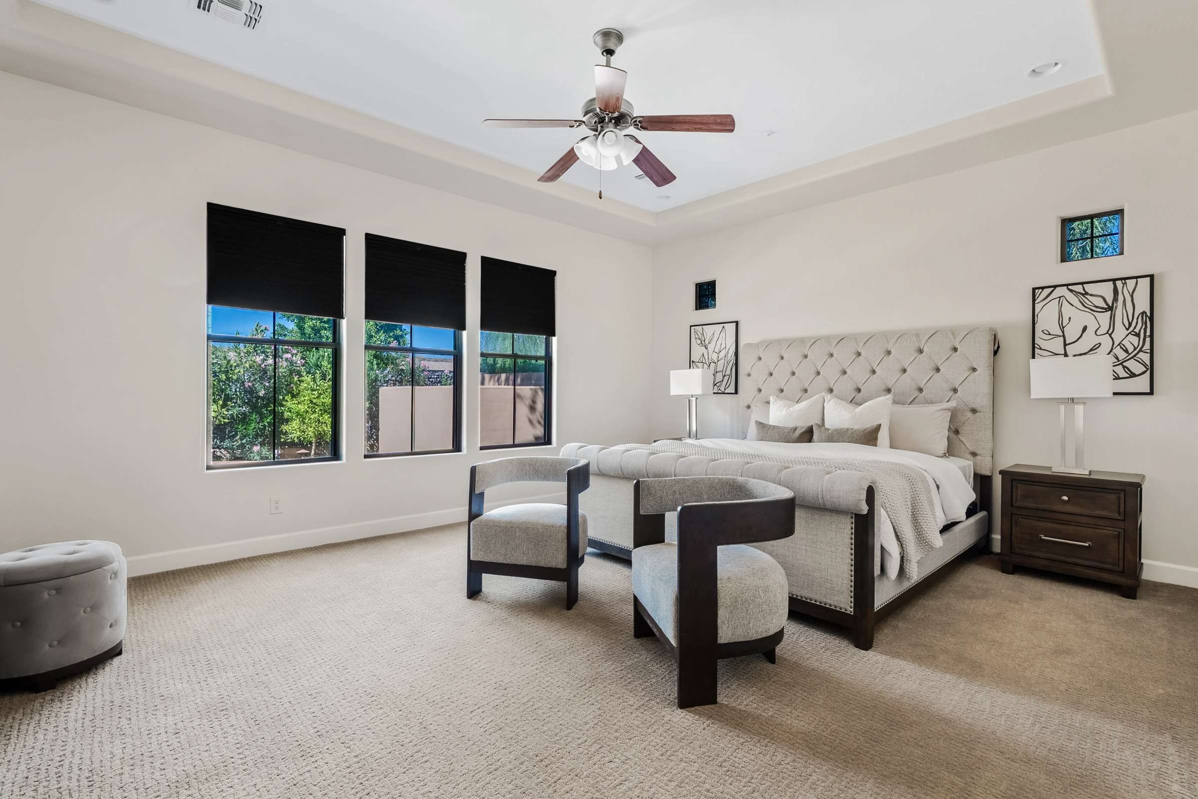 12 of 72. The expansive primary bedroom offers generous proportions, large windows, plush carpeting, and plenty of room for a sitting area. This relaxing retreat enhances the luxury lifestyle found throughout the home.