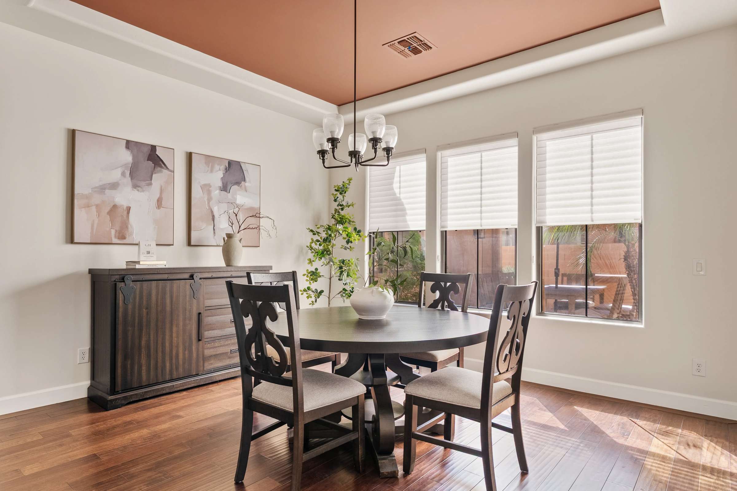 17 of 72. This elegant dining room combines warm wood flooring, tray ceiling details, and abundant natural light to create the perfect space for entertaining and memorable family gatherings.