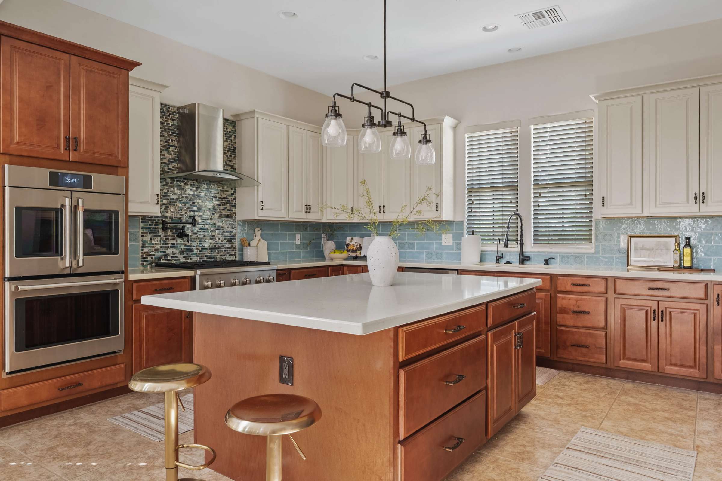19 of 72. An oversized island, quartz countertops, premium stainless steel appliances, double ovens, gas cooktop, and custom cabinetry combine to create a stunning gourmet kitchen for everyday living and entertaining.