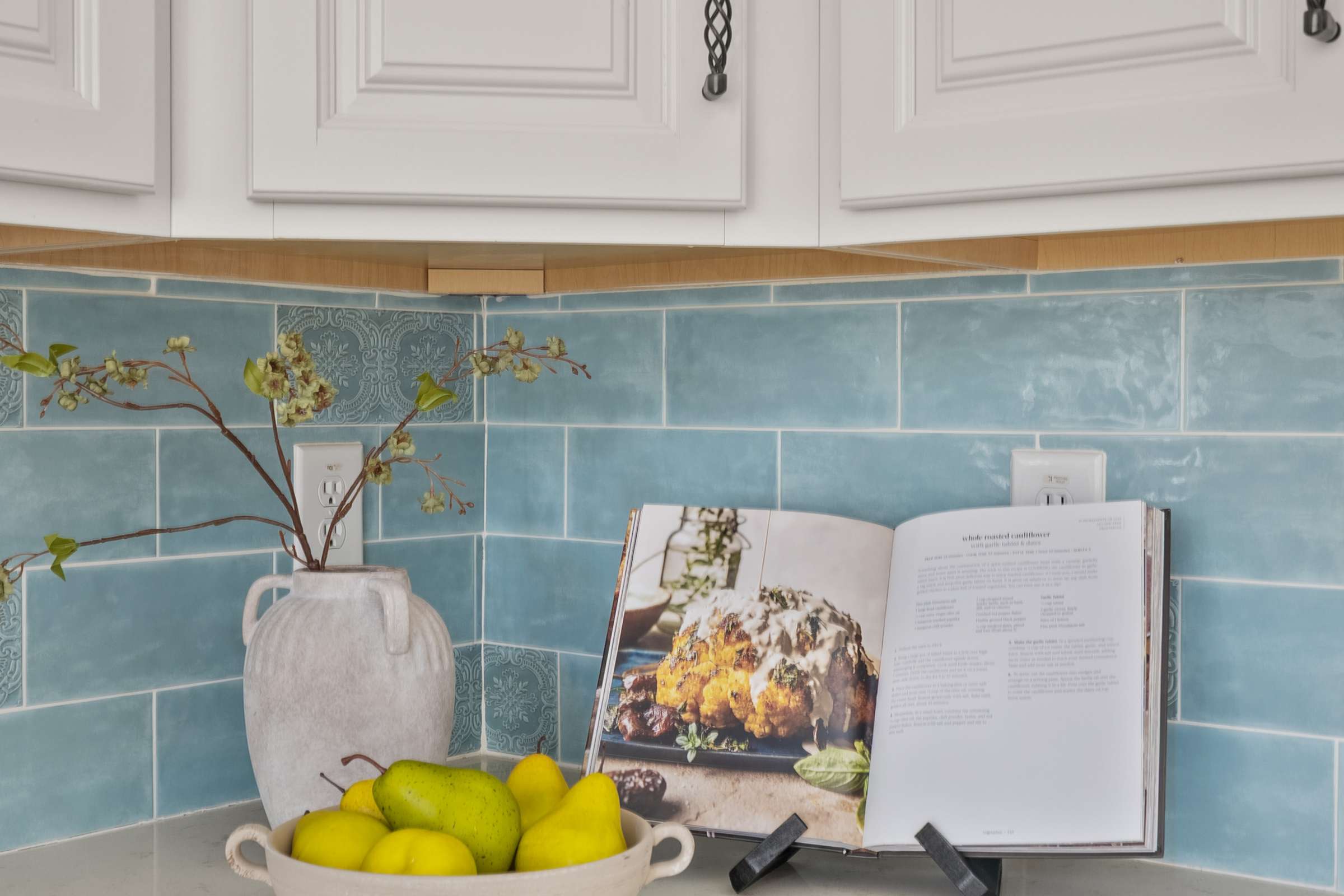 21 of 72. Beautiful quartz countertops, decorative blue tile backsplash, and custom cabinetry combine to create an elegant workspace in this thoughtfully designed Scottsdale kitchen.