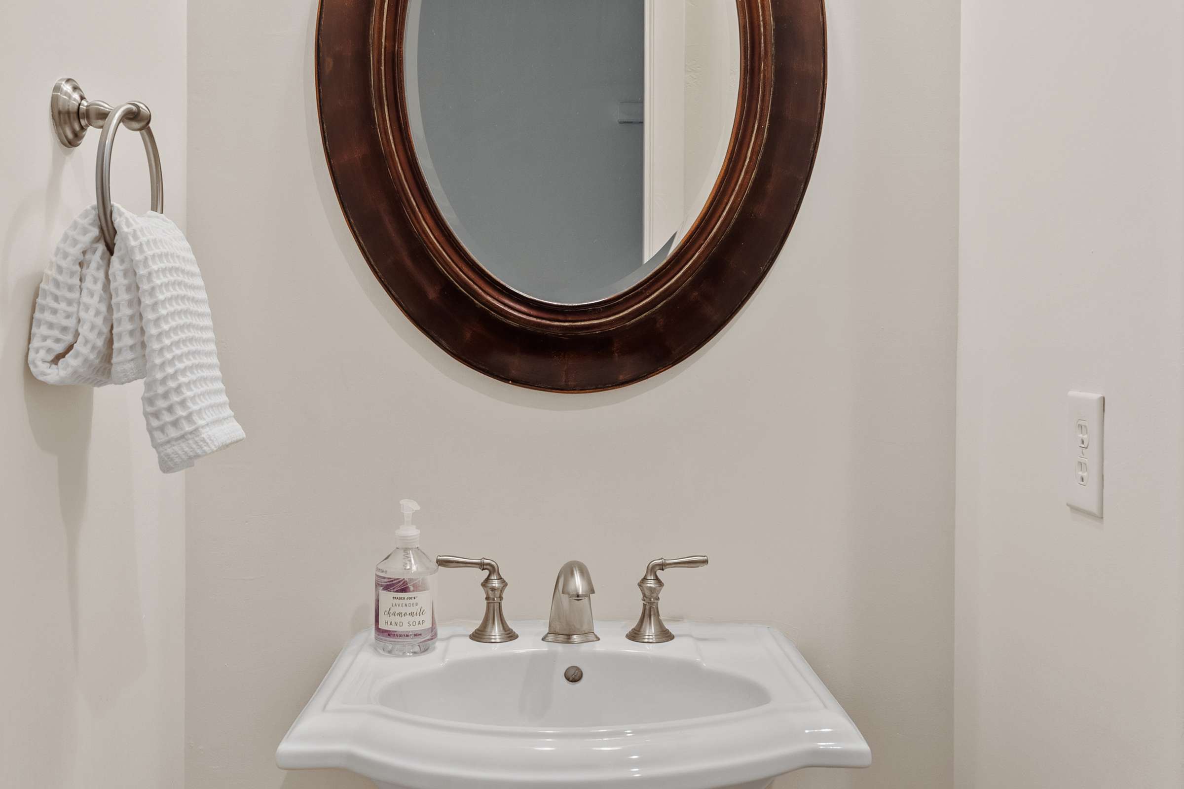 26 of 72. This well-appointed powder room features a pedestal sink, elegant lighting, and timeless finishes, providing a stylish and convenient space for visitors.