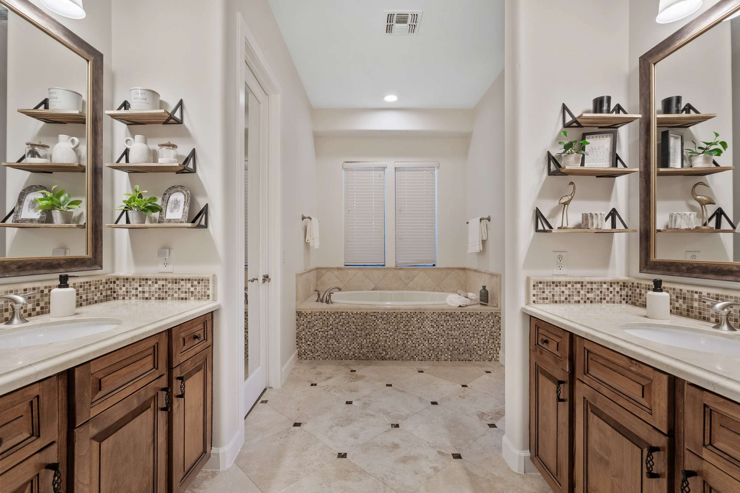30 of 72. Dual vanities, custom cabinetry, elegant stone flooring, a soaking tub, and premium finishes create a luxurious primary bathroom that perfectly complements this exceptional Scottsdale home.