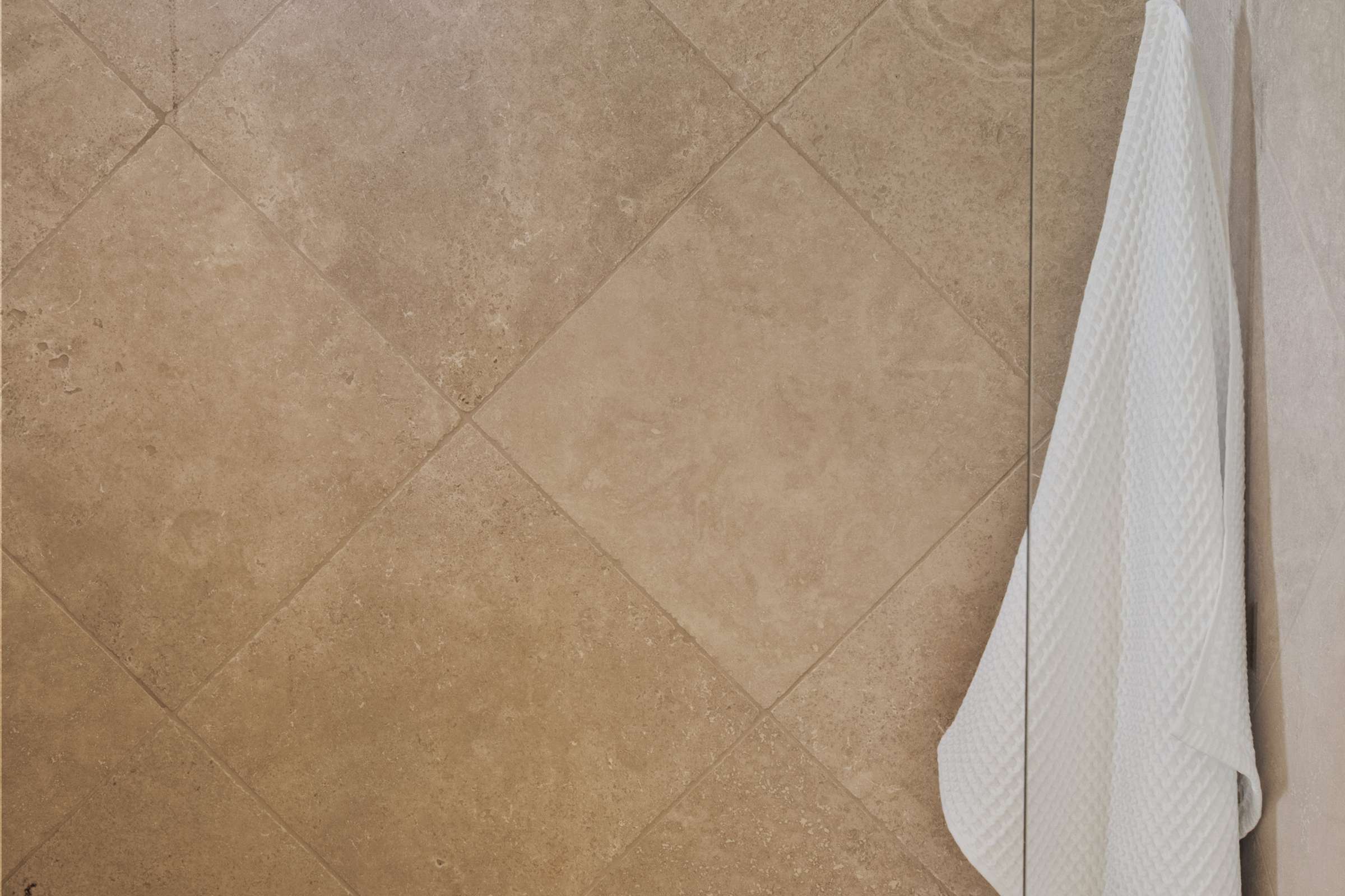 34 of 72. The walk-in shower features elegant floor-to-ceiling tile, decorative mosaic accents, natural lighting, and spacious proportions for a spa-like bathing experience.