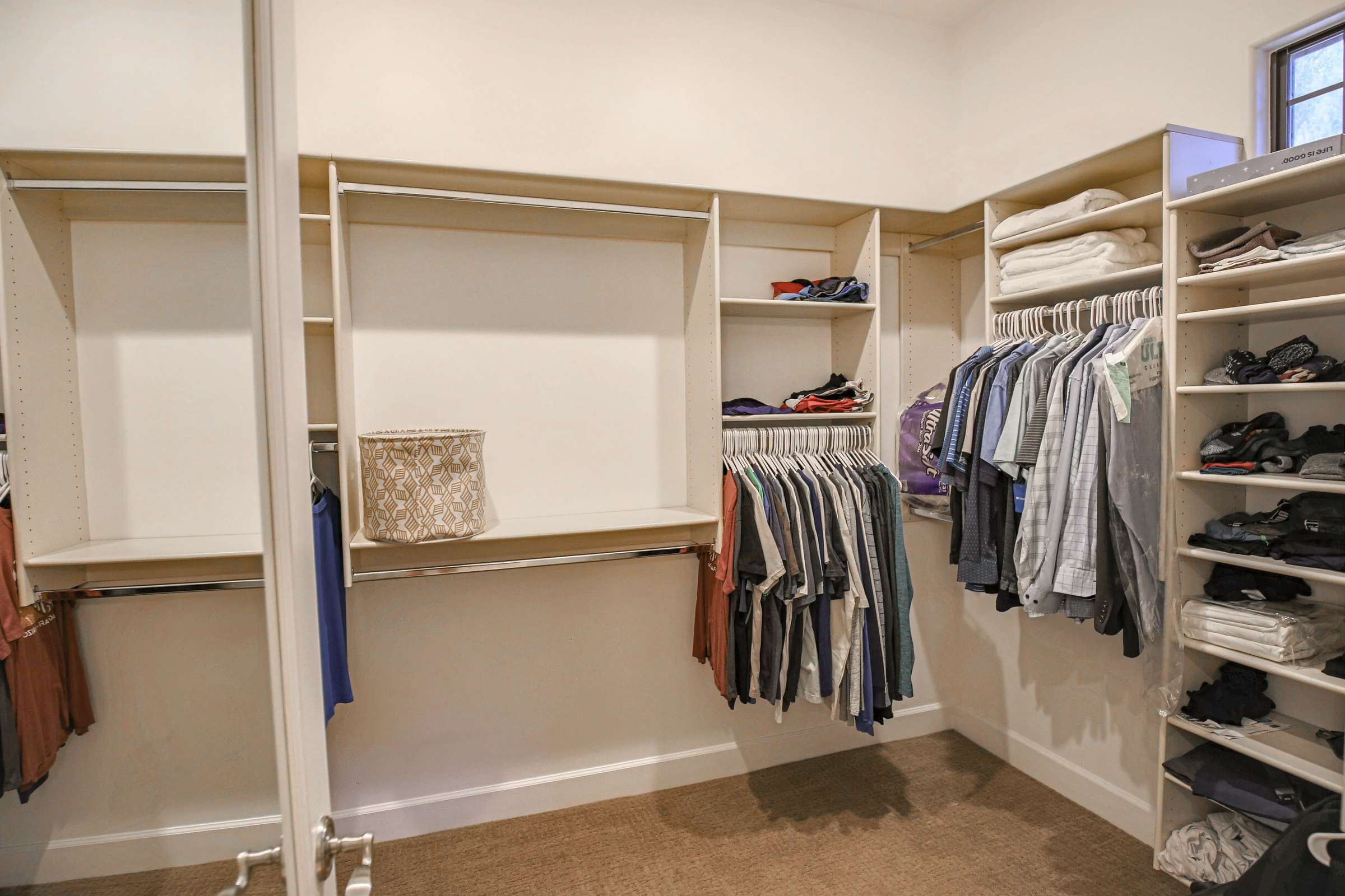 35 of 72. Custom closet organizers, built-in shelving, and extensive hanging space provide exceptional storage and organization within this oversized primary walk-in closet.