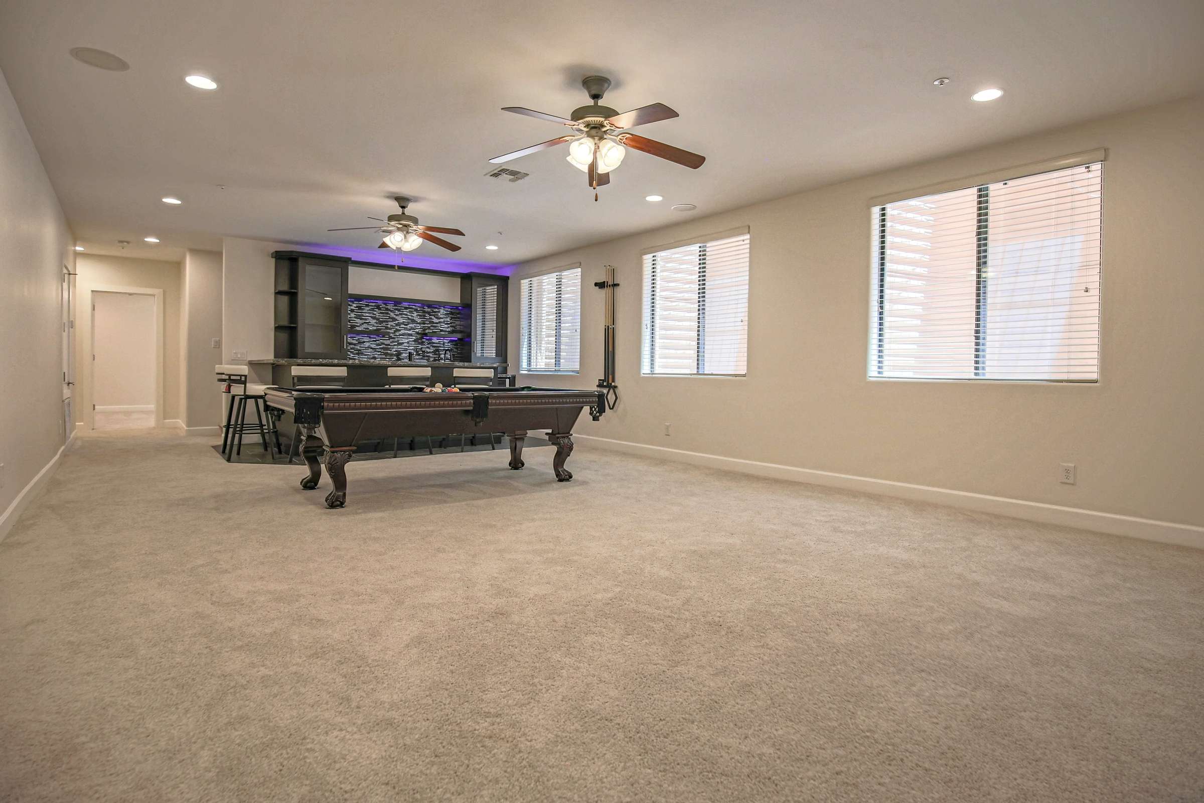 49 of 72. The expansive basement provides exceptional flexibility with room for entertaining, recreation, gaming, or media while showcasing custom finishes and an adjoining wet bar in this Scottsdale home.