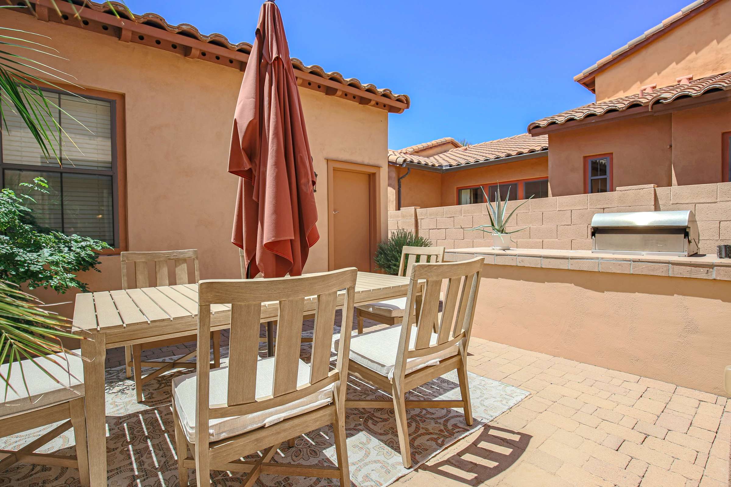 55 of 72. Entertain outdoors on the private courtyard featuring paver patios, built-in BBQ, dining space, and low-maintenance landscaping that extends the home's indoor-outdoor lifestyle in Scottsdale.