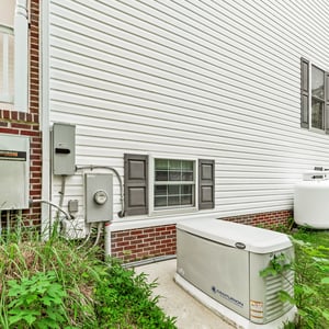 This property features a well-maintained exterior with essential utilities like owned propane tanks and a whole-house backup generator readily accessible for convenience.